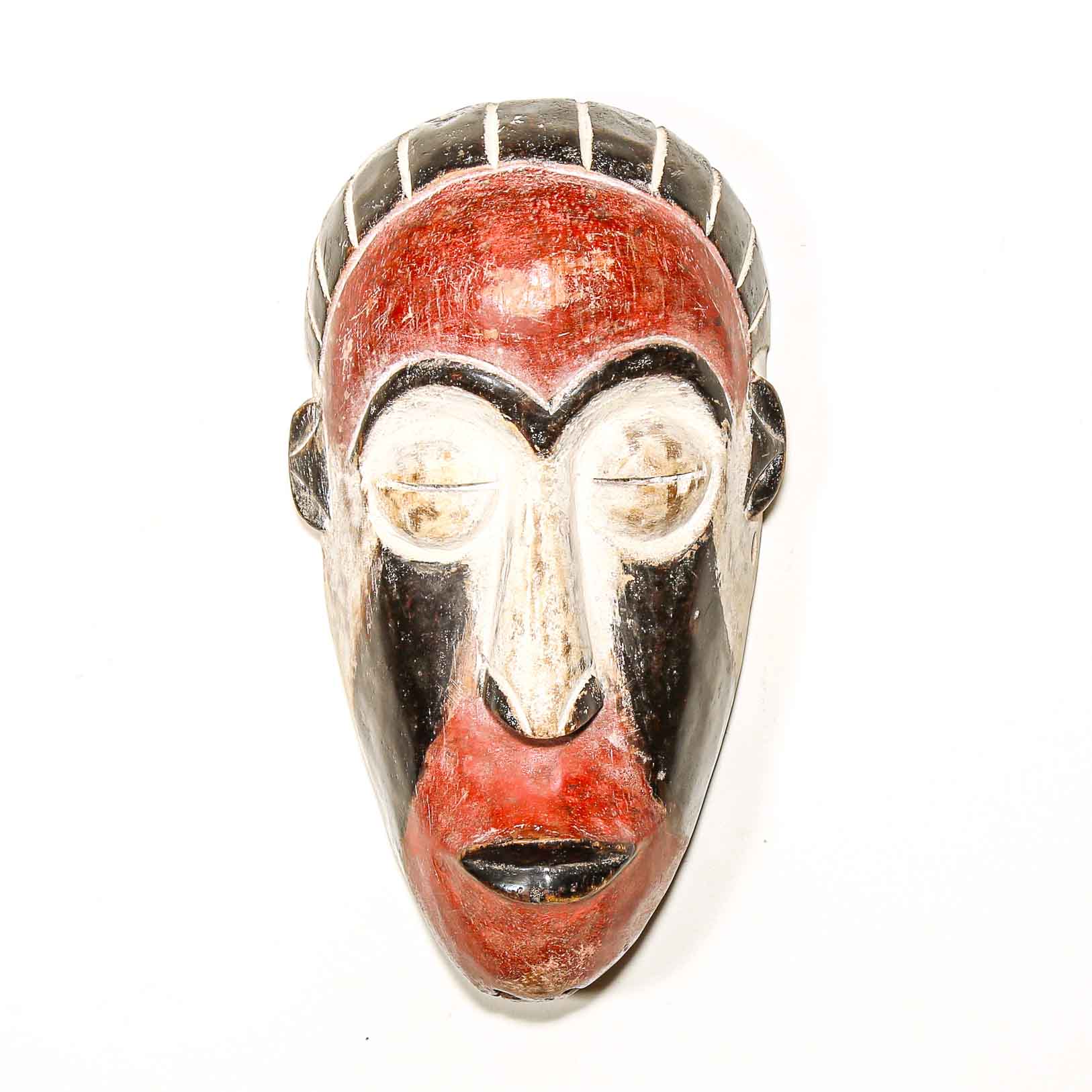 Ceremonial African mask with red and silver colors on a white background