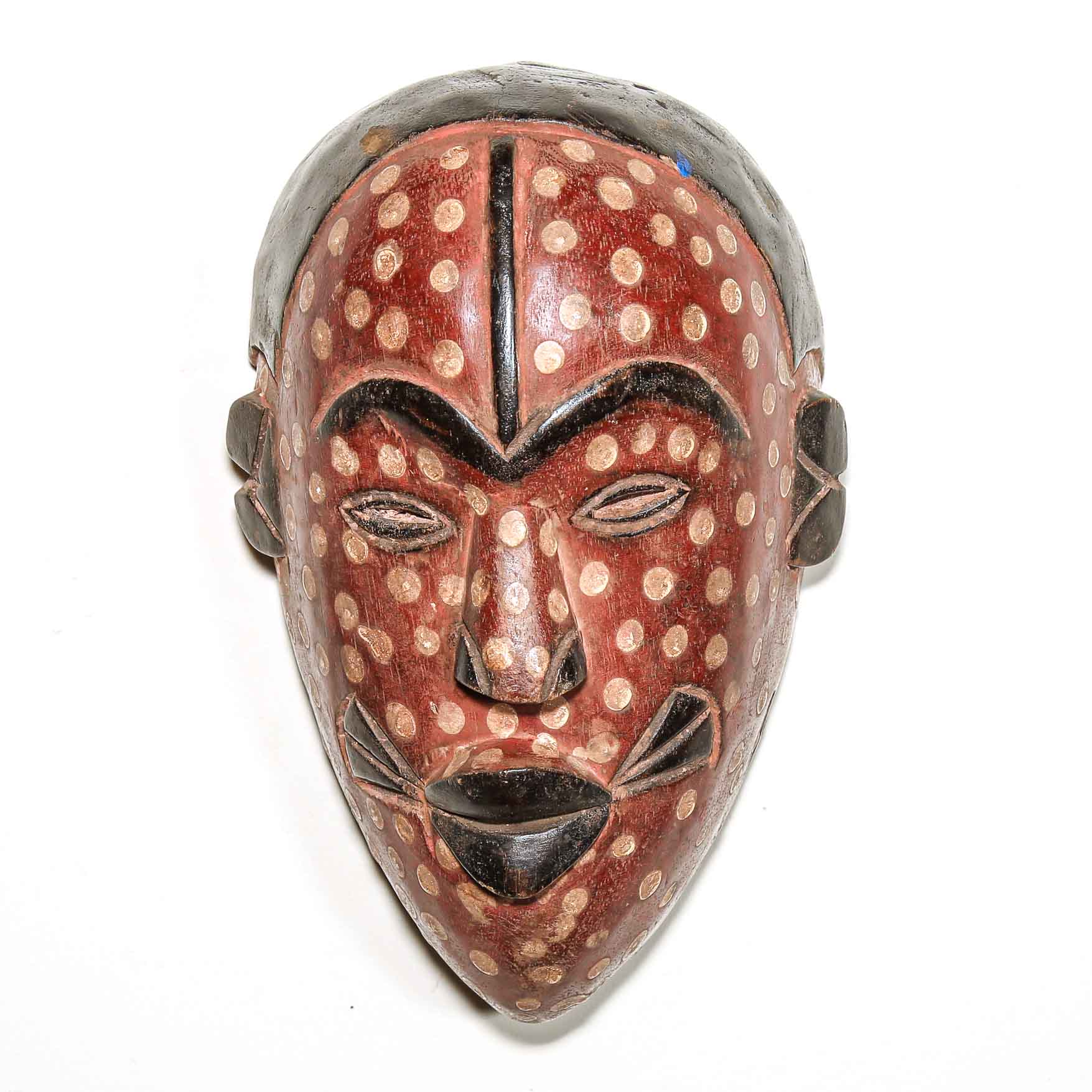 Wooden mask with red and brown design on a white background