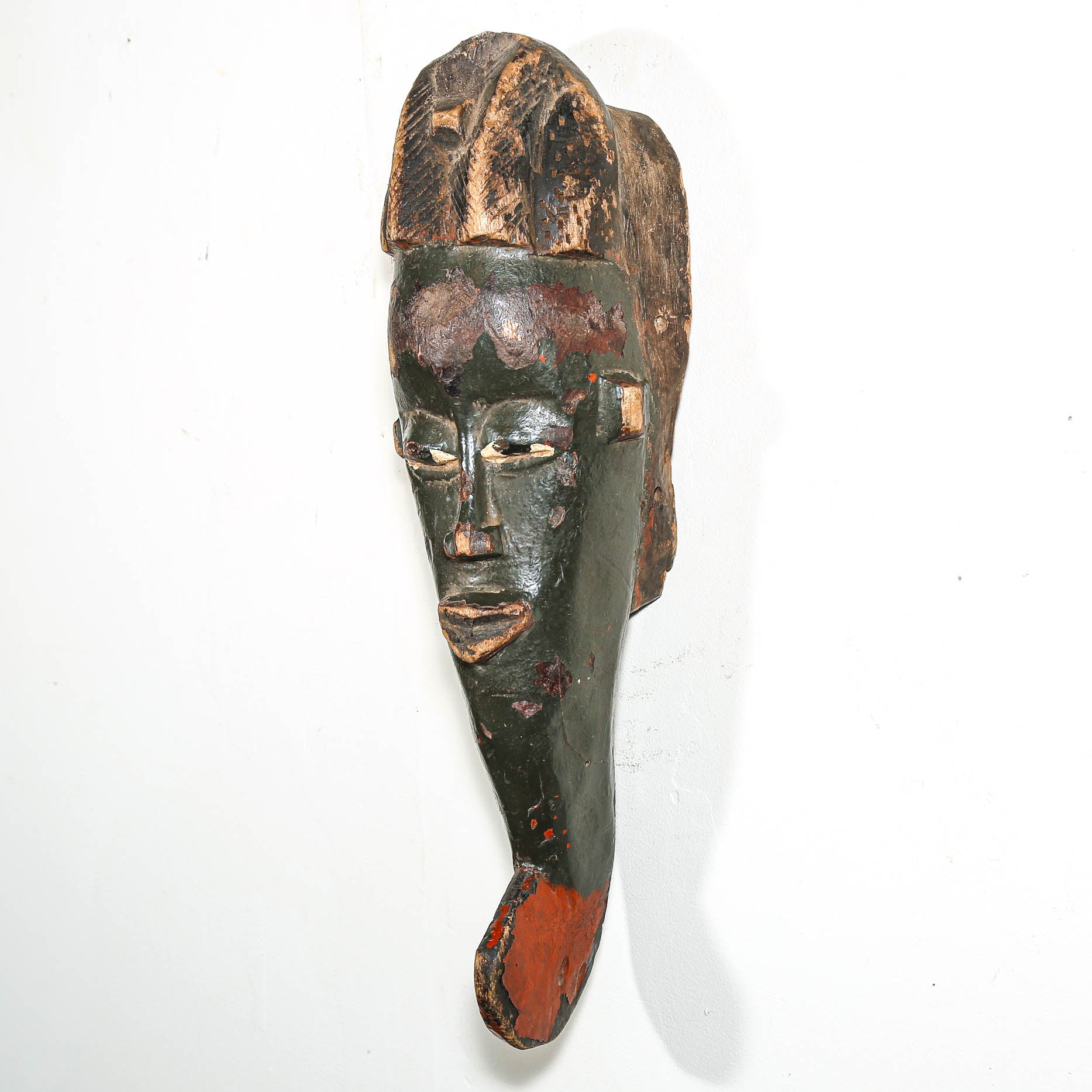 Wooden mask with black and red paint on a white background