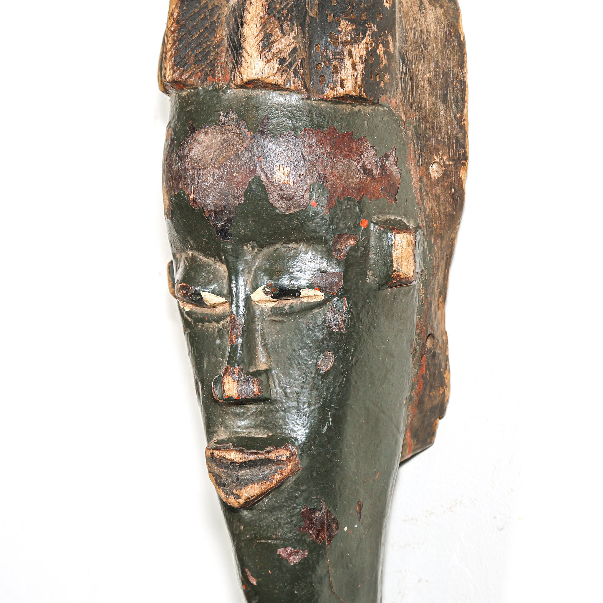African Wooden mask with a dark green face on a white background