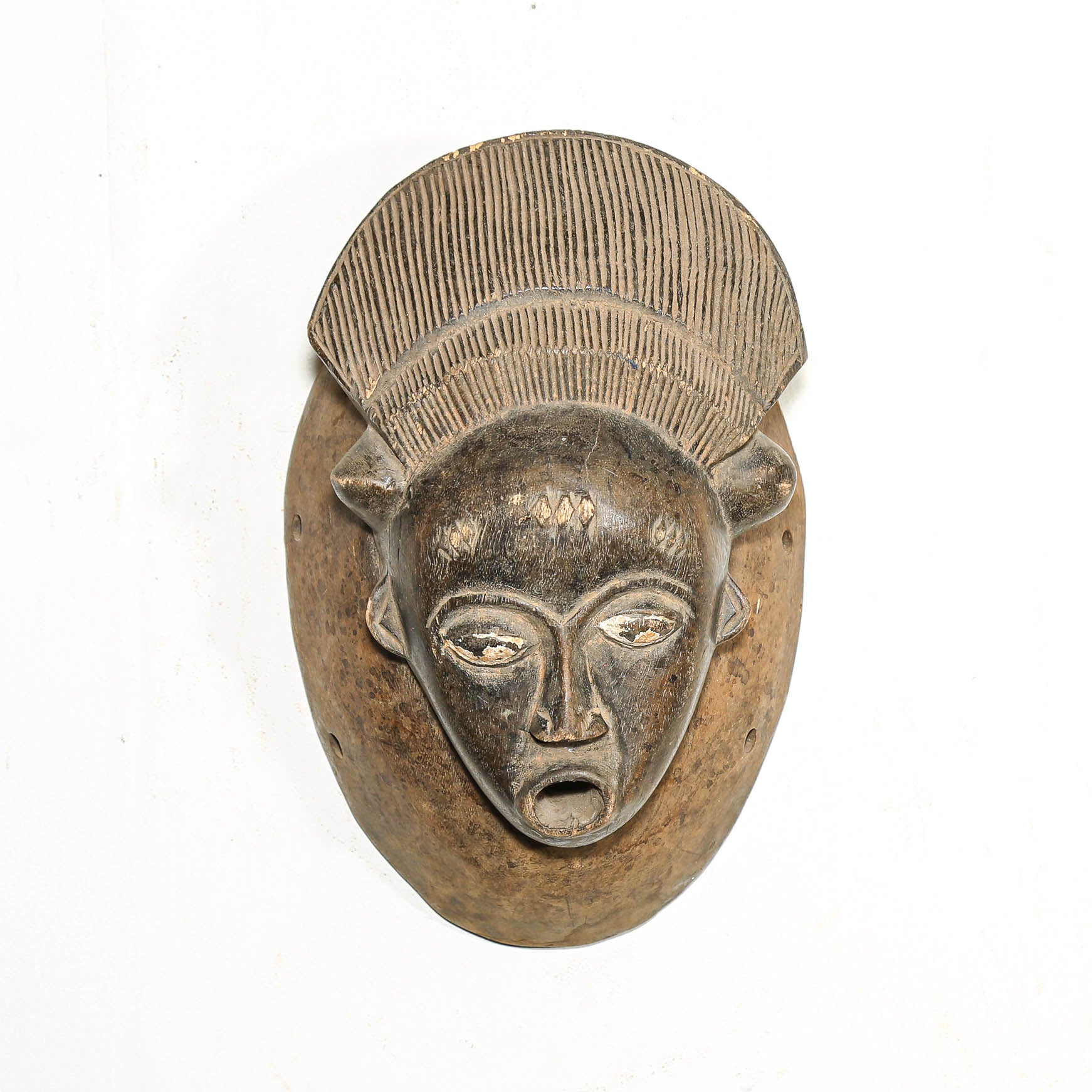 Wood mask from Africa with a textured top on a white background