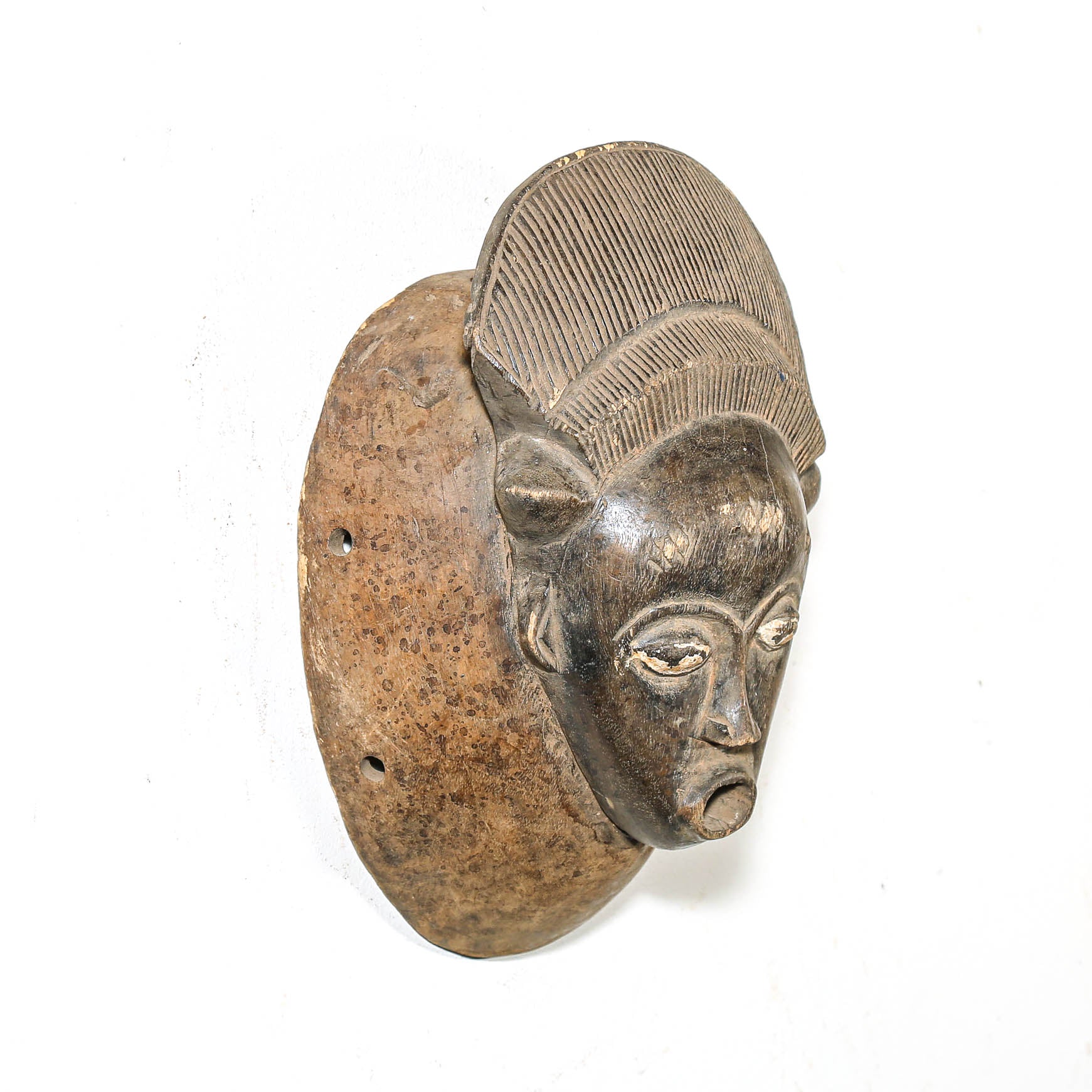 Wood mask from Africa with a textured top on a white background