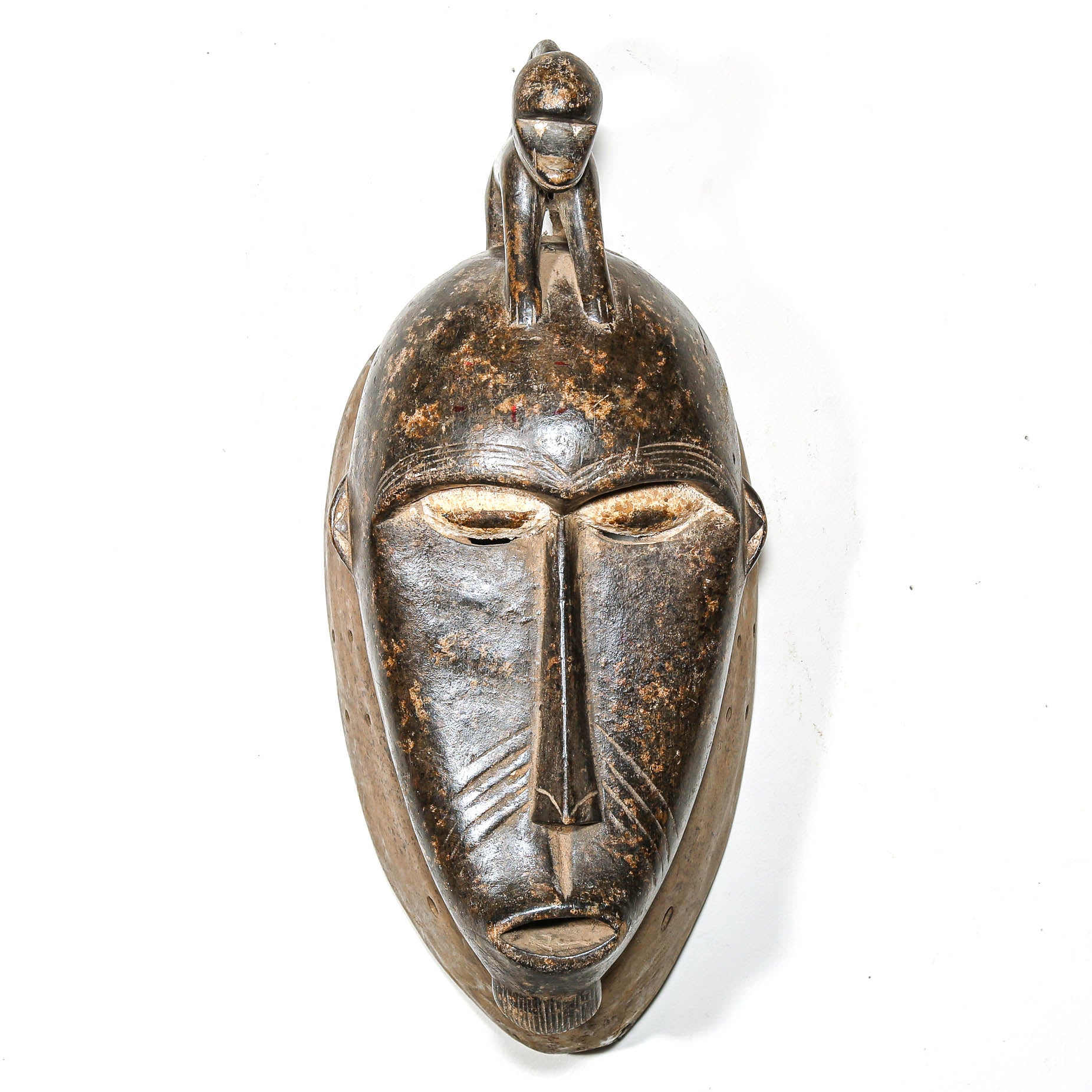 African mask with intricate designs on a white background