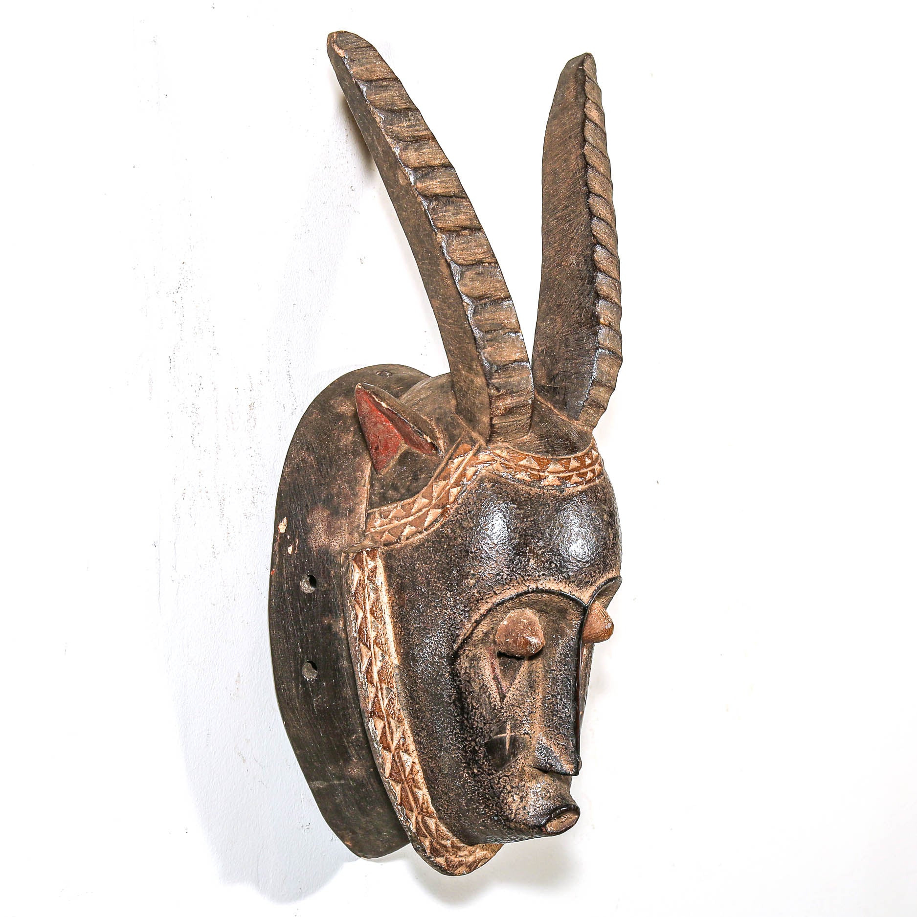 Wooden africa mask with antelope features on a white background
