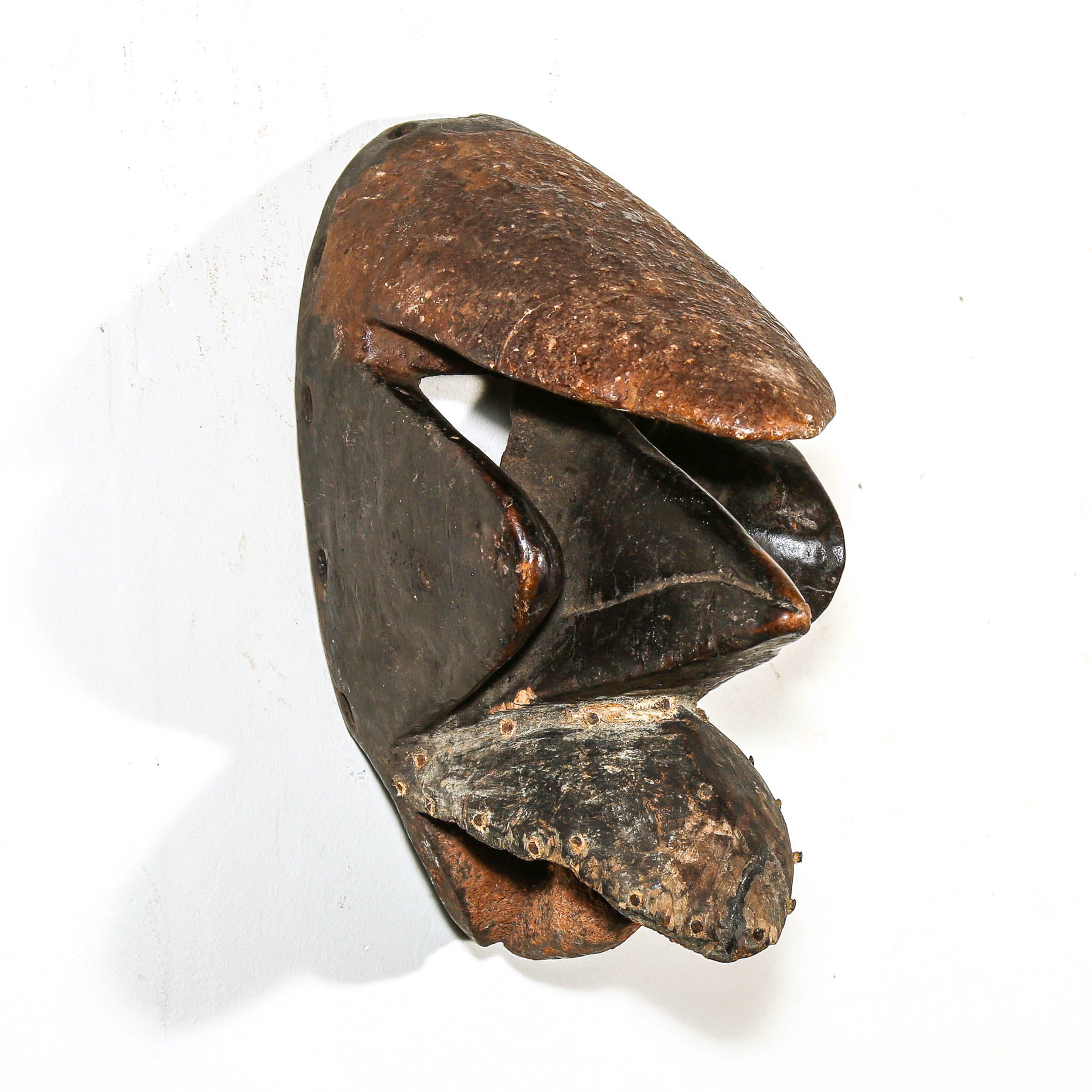 Black African art wood mask with a white collector's wall