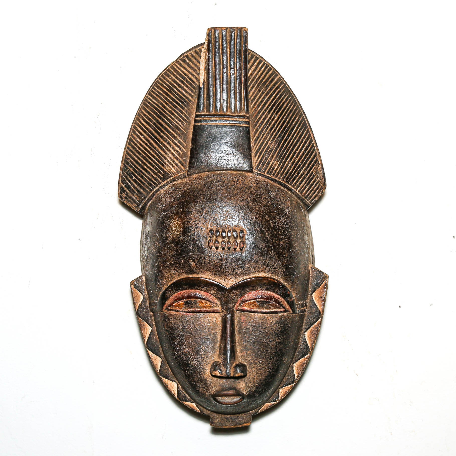 African mask with intricate design on a white background