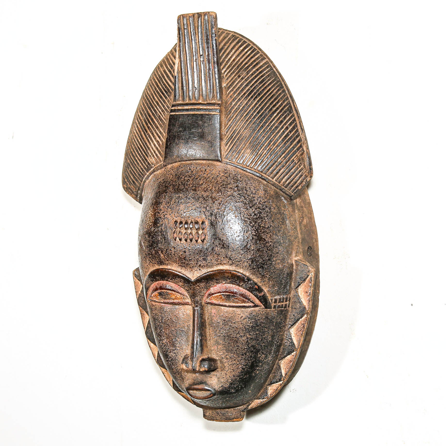 African mask with detailed carvings on a white background for home design