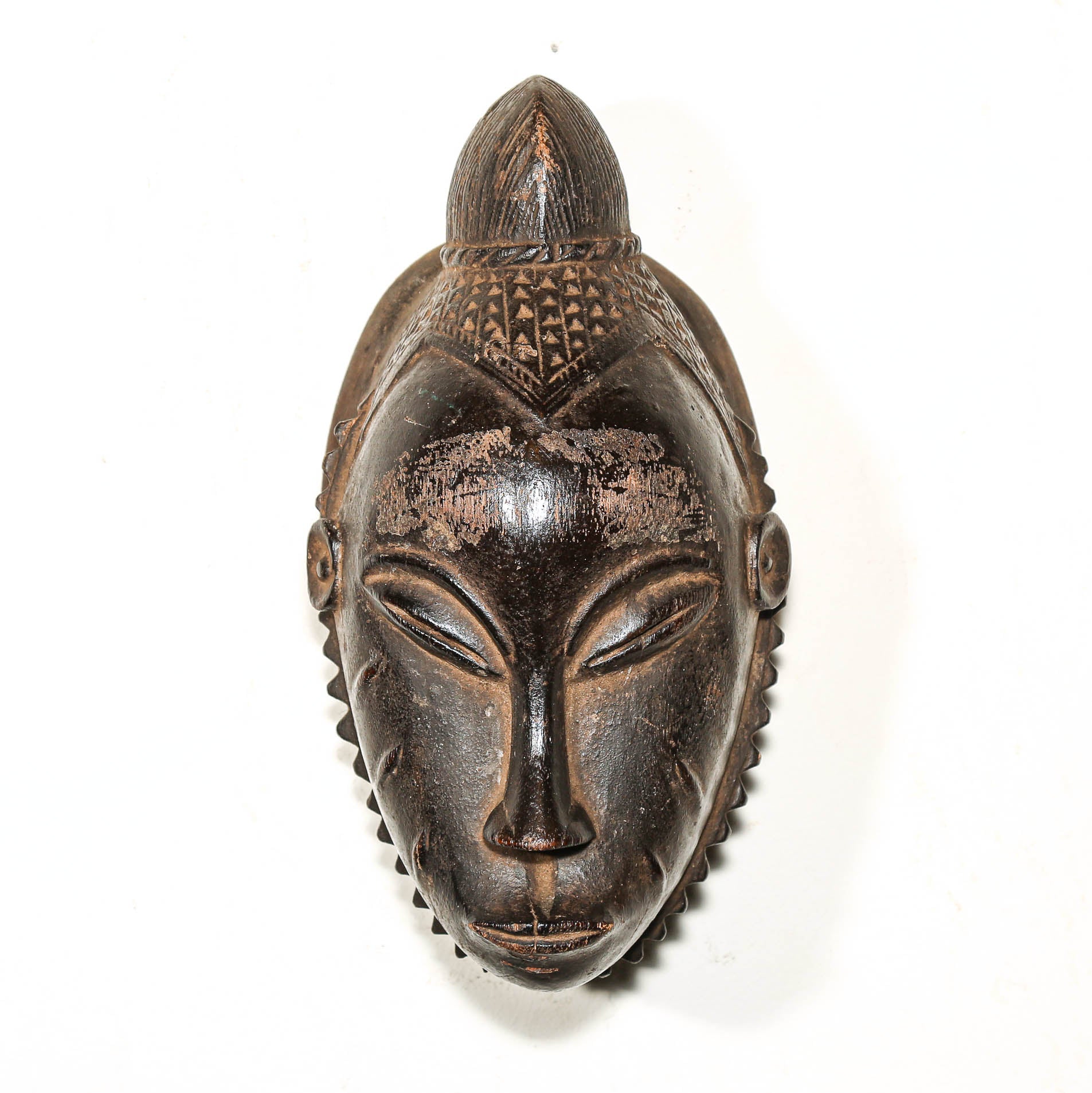 Black African mask with intricate designs on a white background