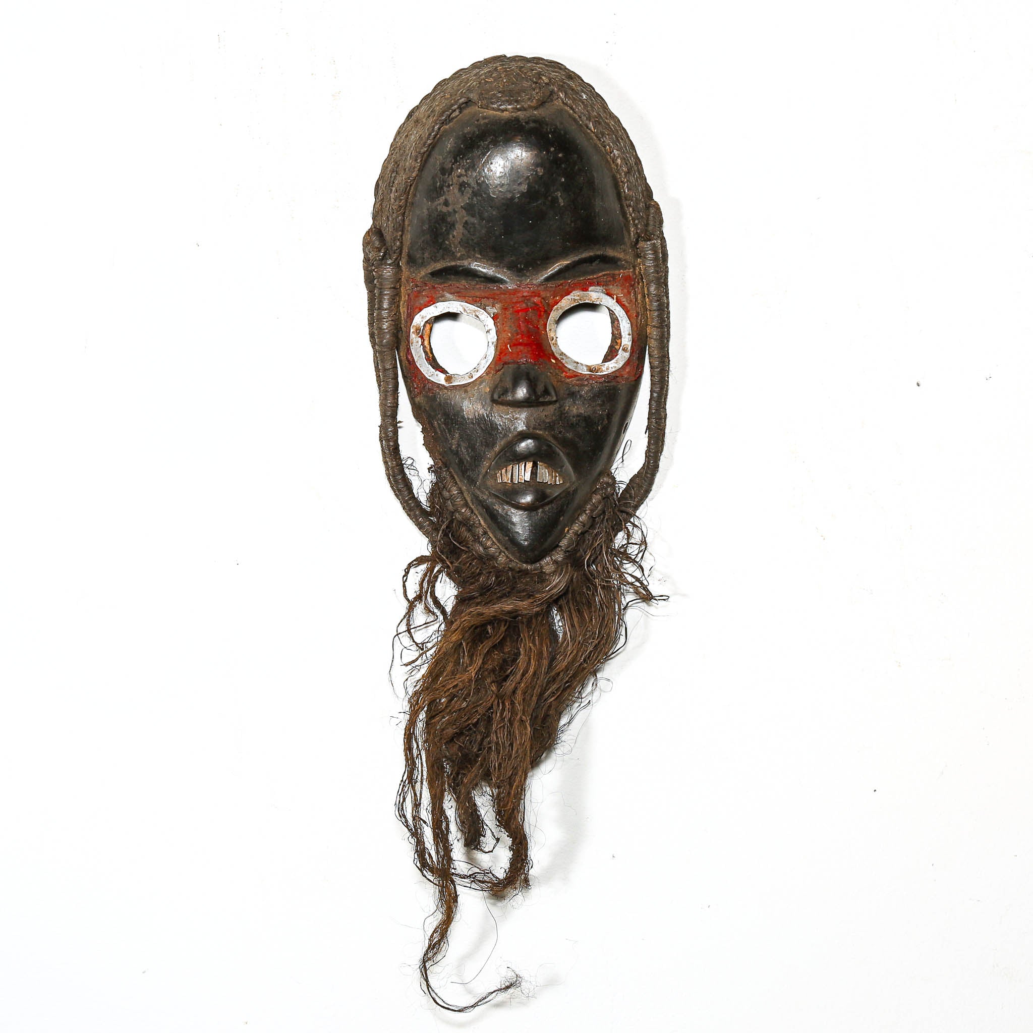 Traditional african wooden mask with braided hair on a white background