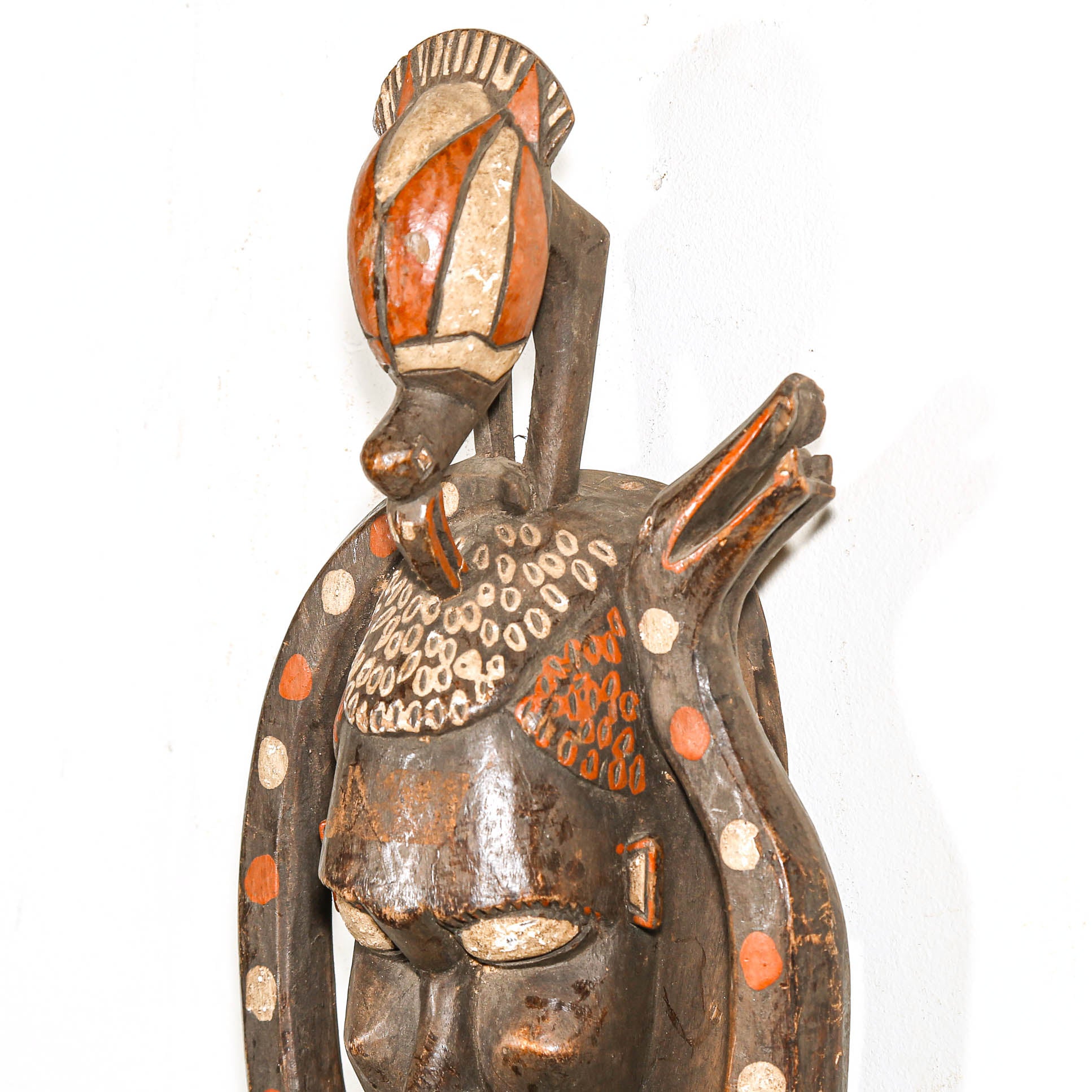 Decorative wooden mask with intricate carvings on a white background