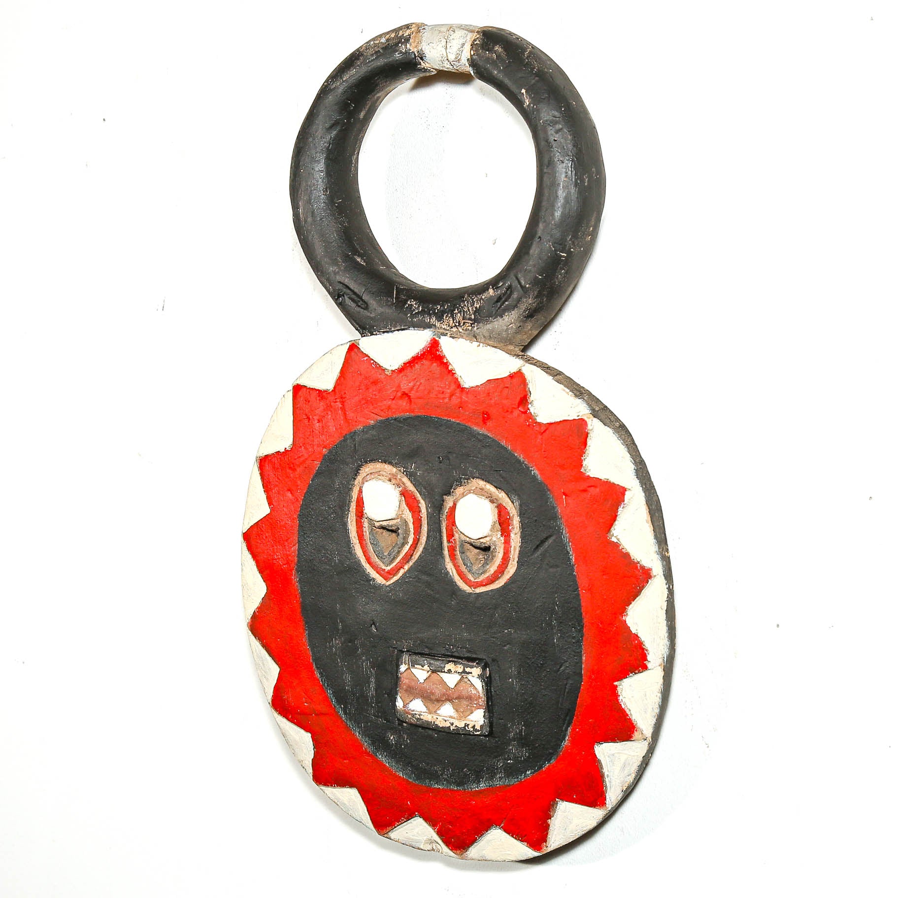Round wooden African mask with a red and black face design on a white background