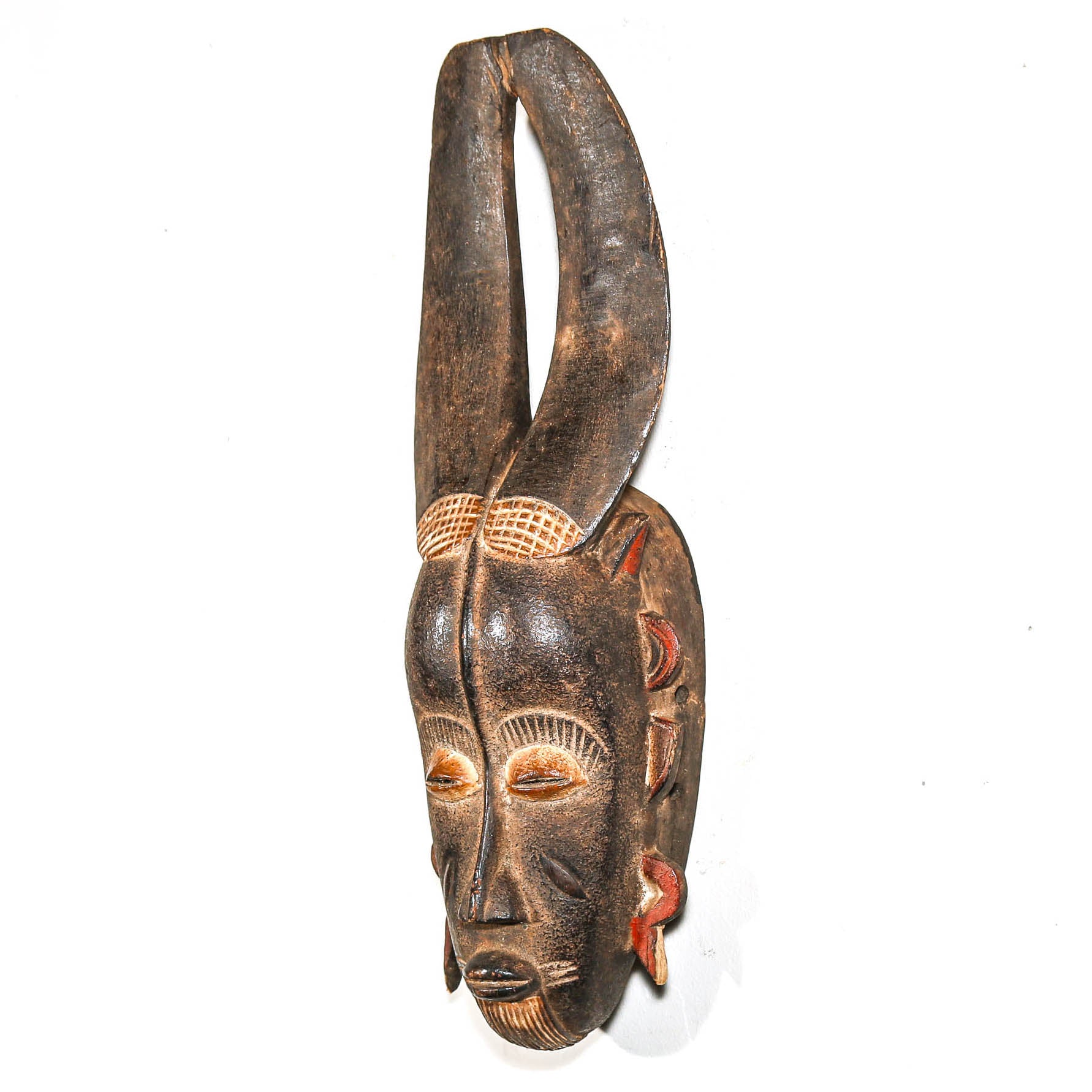 Wooden mask from Africa with long horns on a white background