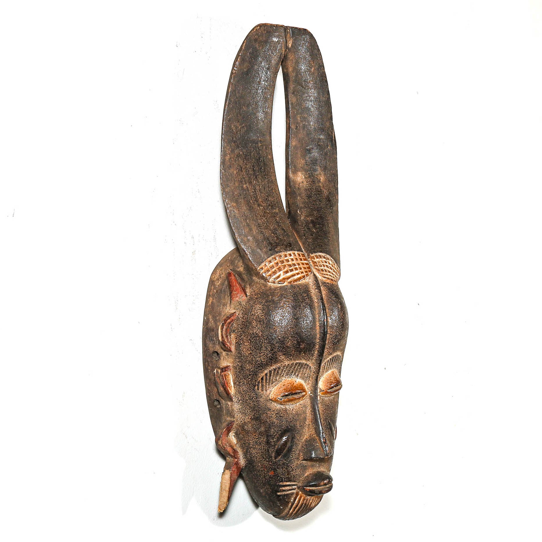 Wooden mask with intricate carvings on a white background