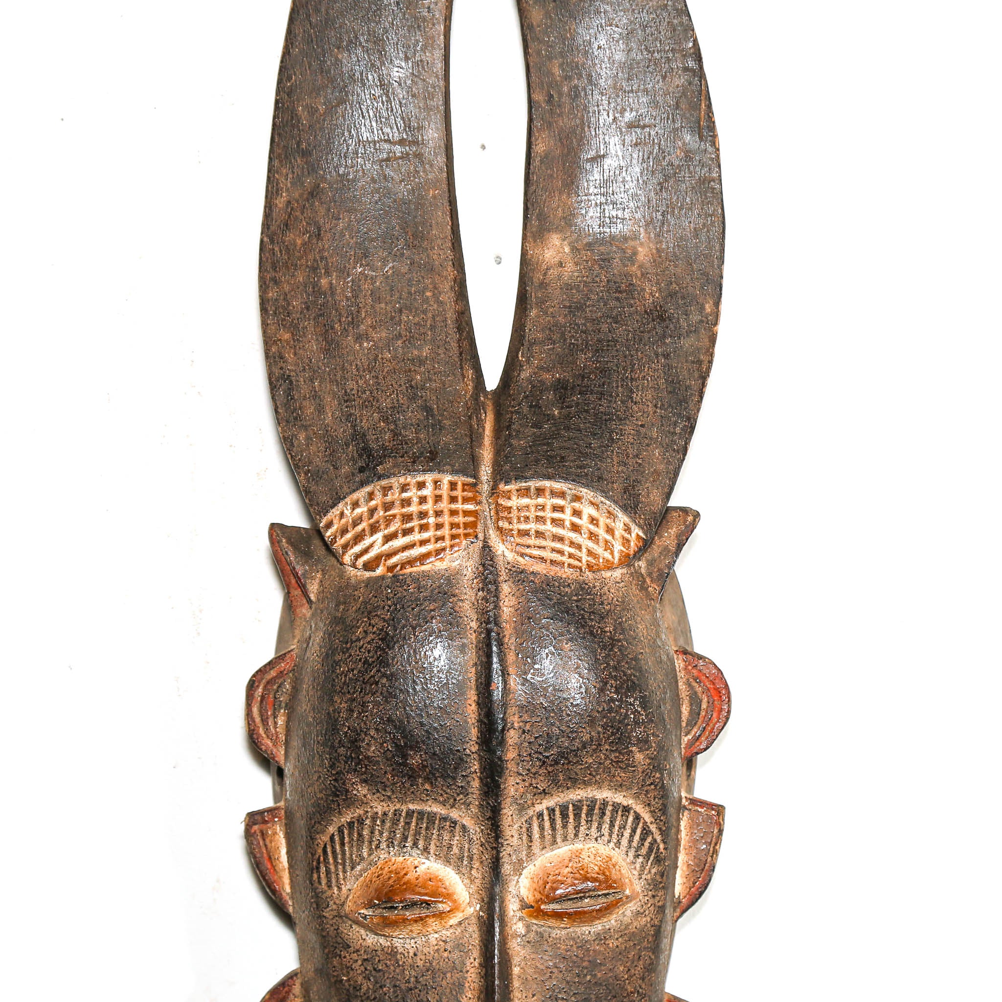 African wooden mask with detailed carvings on a white background