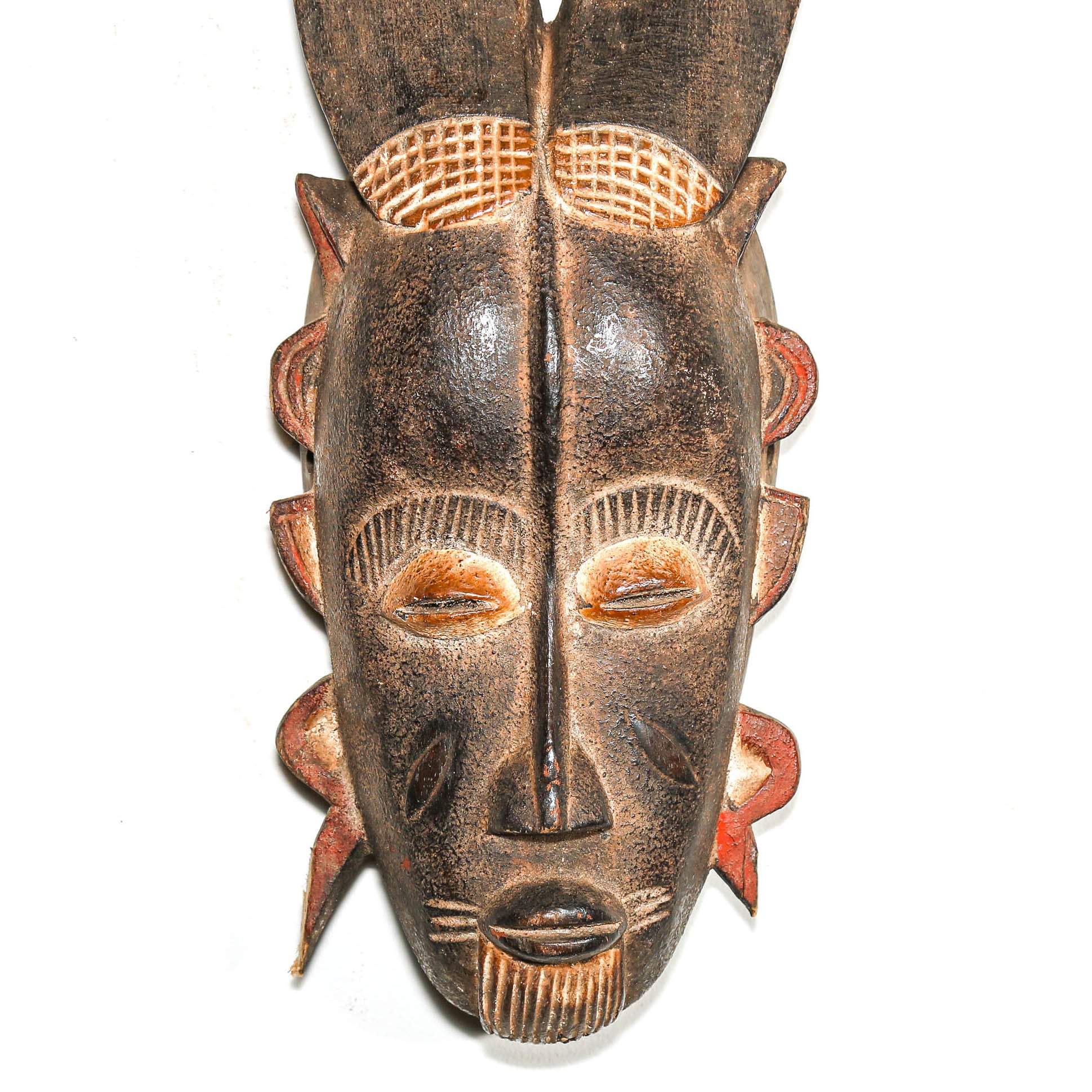 African mask with detailed carvings on a white background