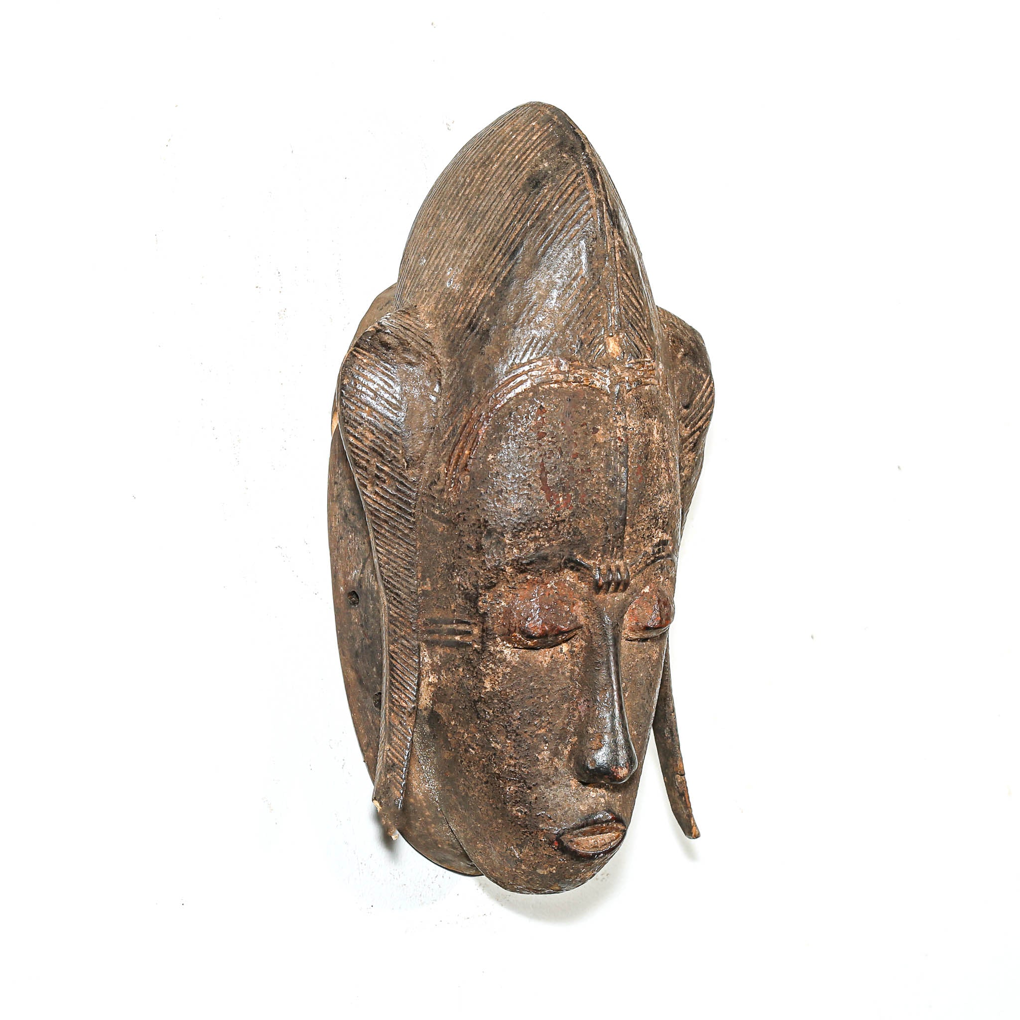 Wooden tribal African mask with detailed facial features on a white background