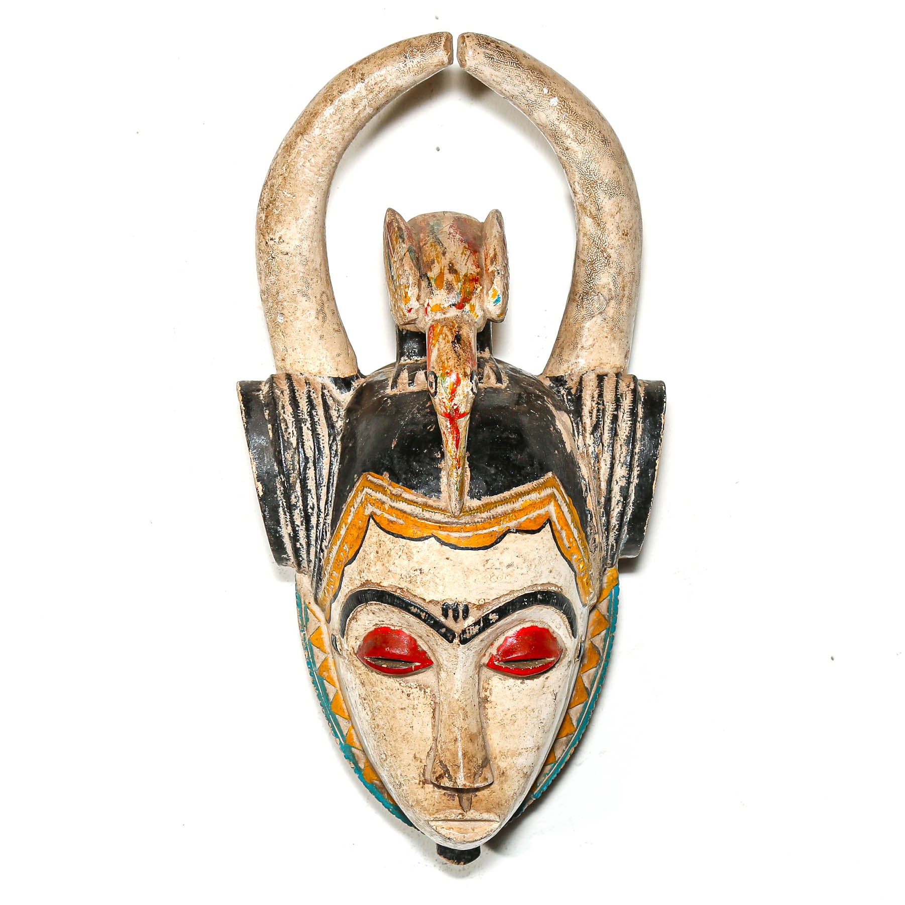 Decorative tribal mask with red eyes and intricate design on a white background