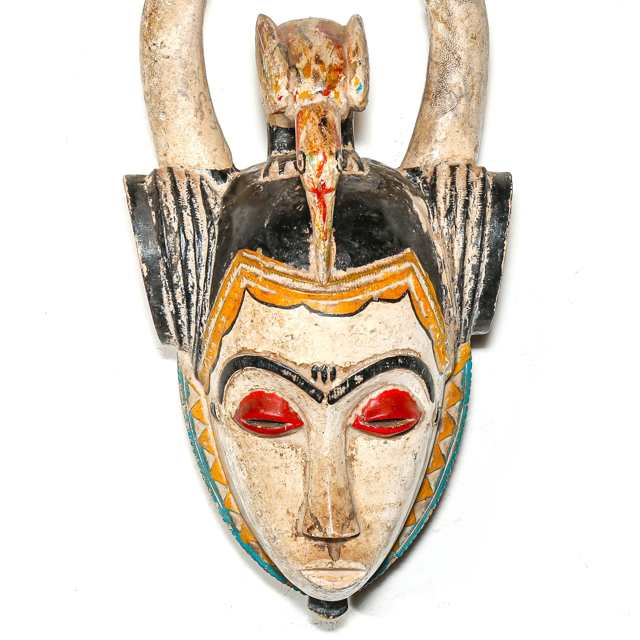 colorful ceremonial mask with red eyes and colorful patterns on a white background