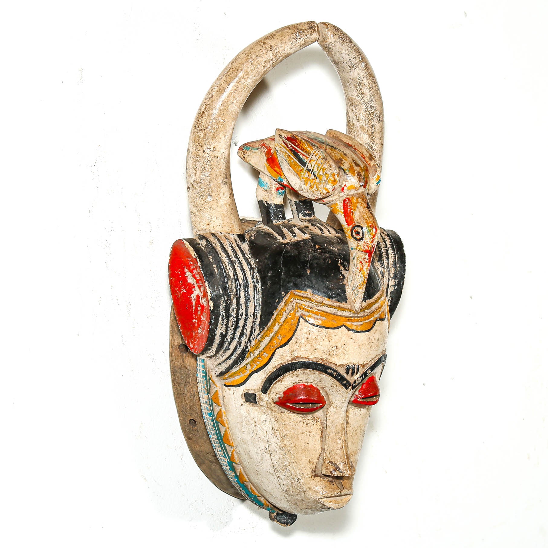 Traditional wooden mask with colorful decorations on a white background