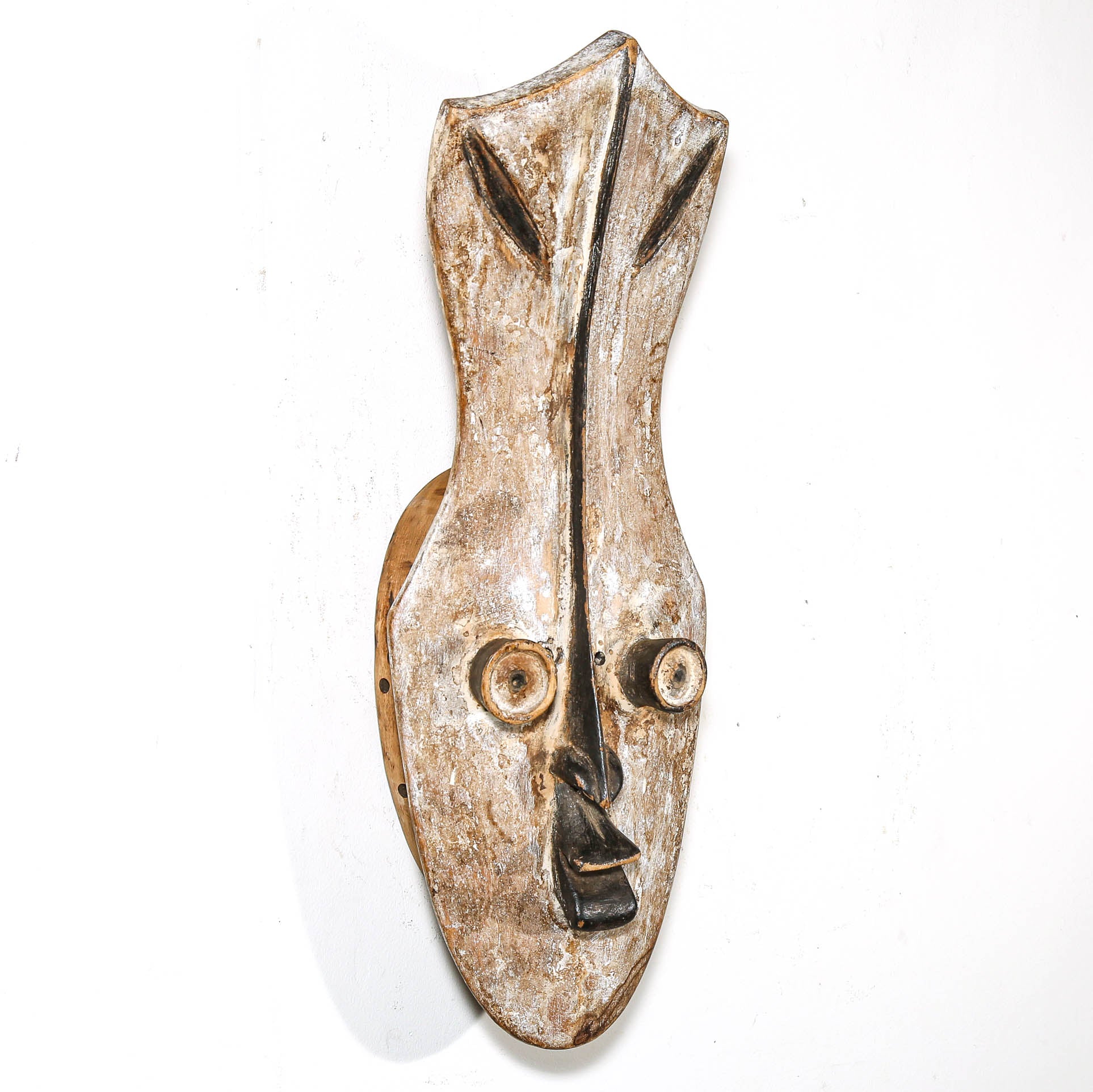 Decorative African mask with a rustic, worn finish on a white background