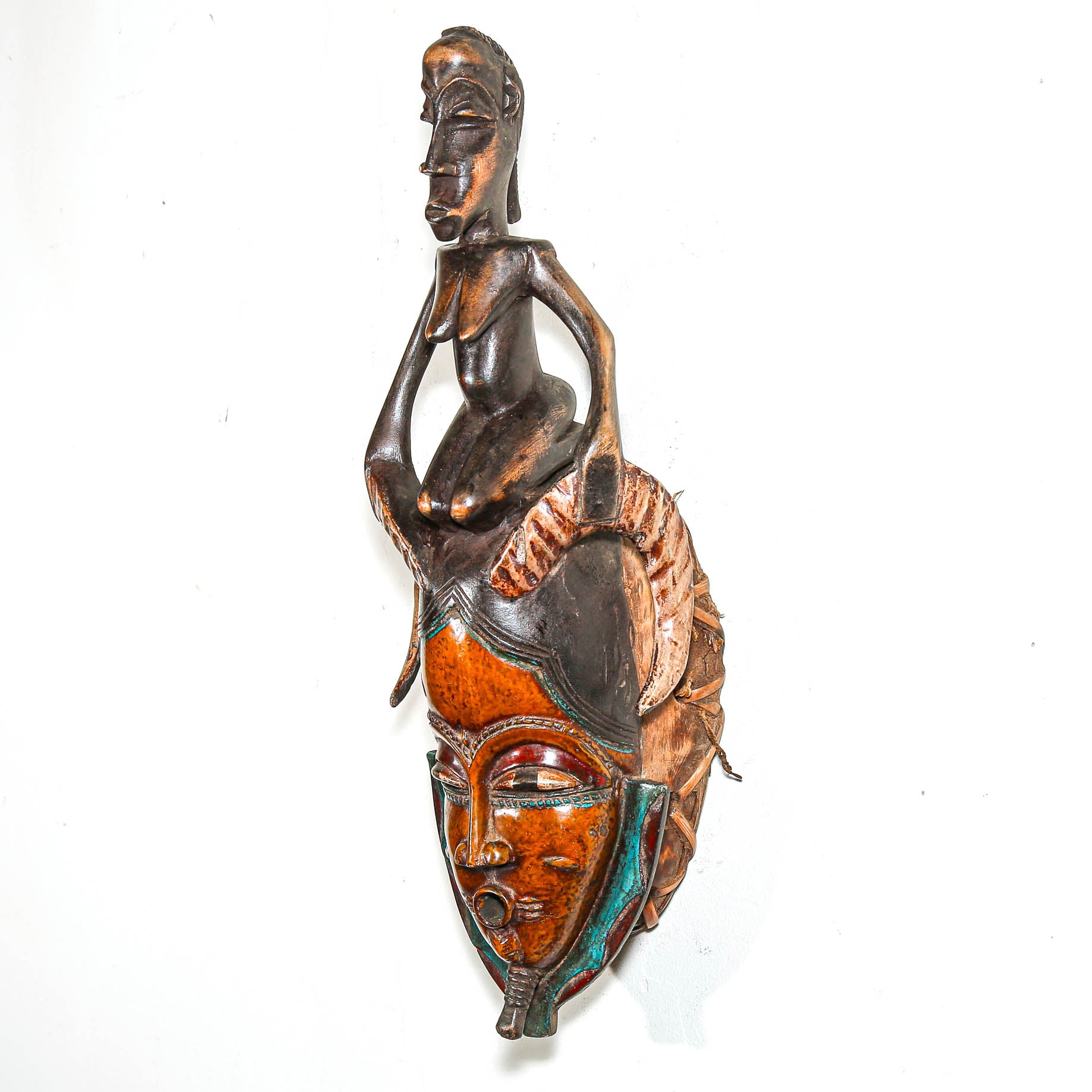 Decorative wall art from Africa with a figure and mask design on a white background