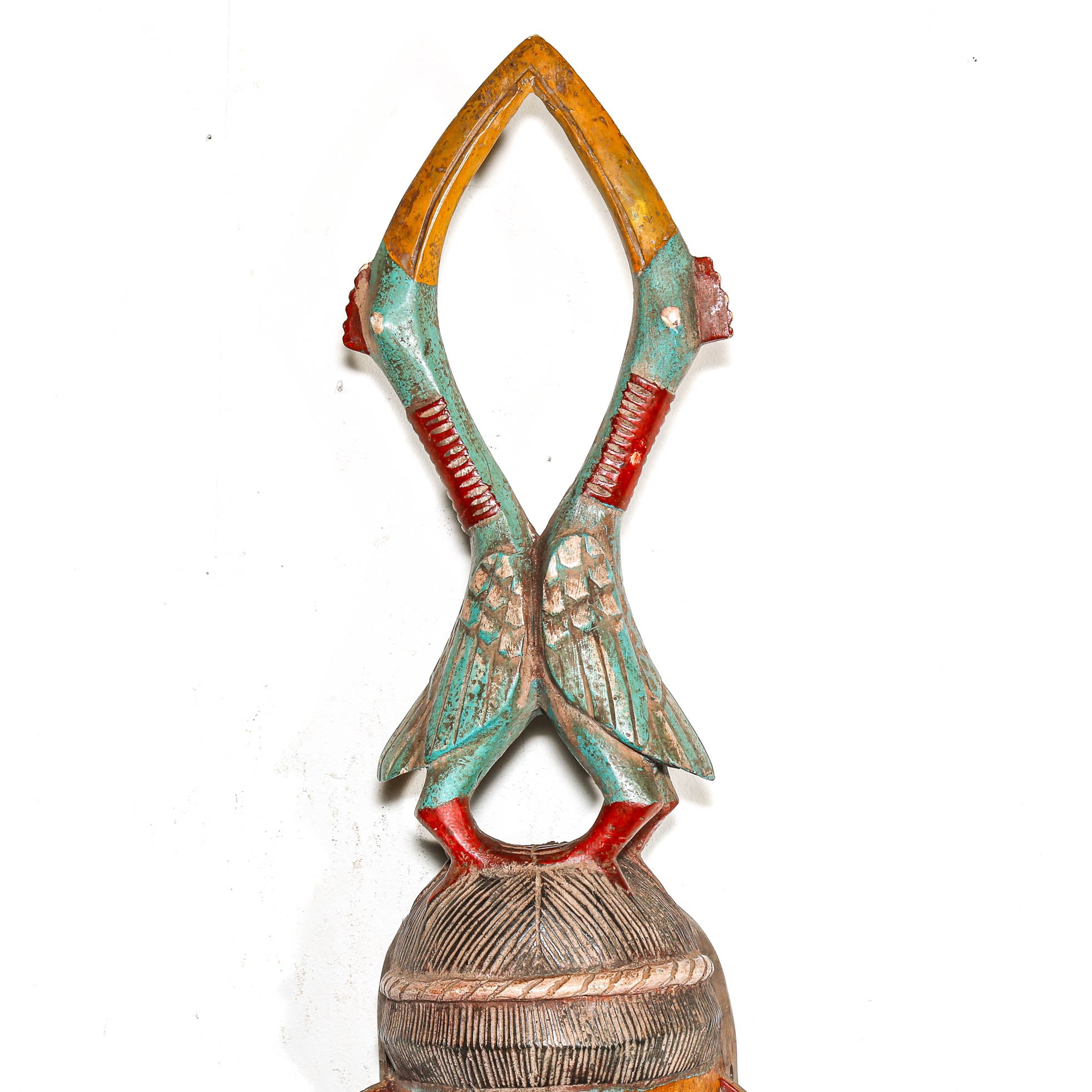 two hand carved colorful birds on an African mask