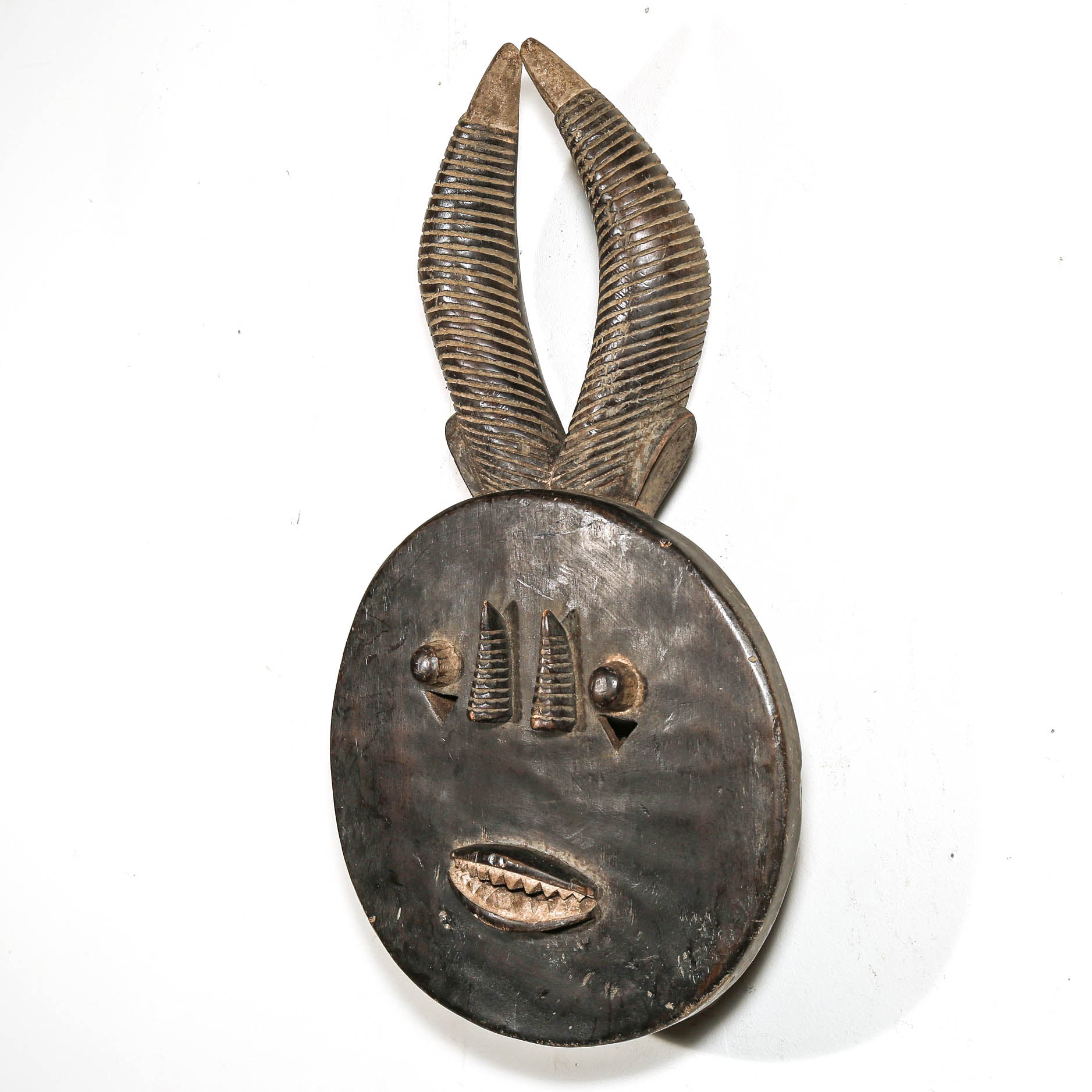 Decorative black african mask with antelope horns on a white background