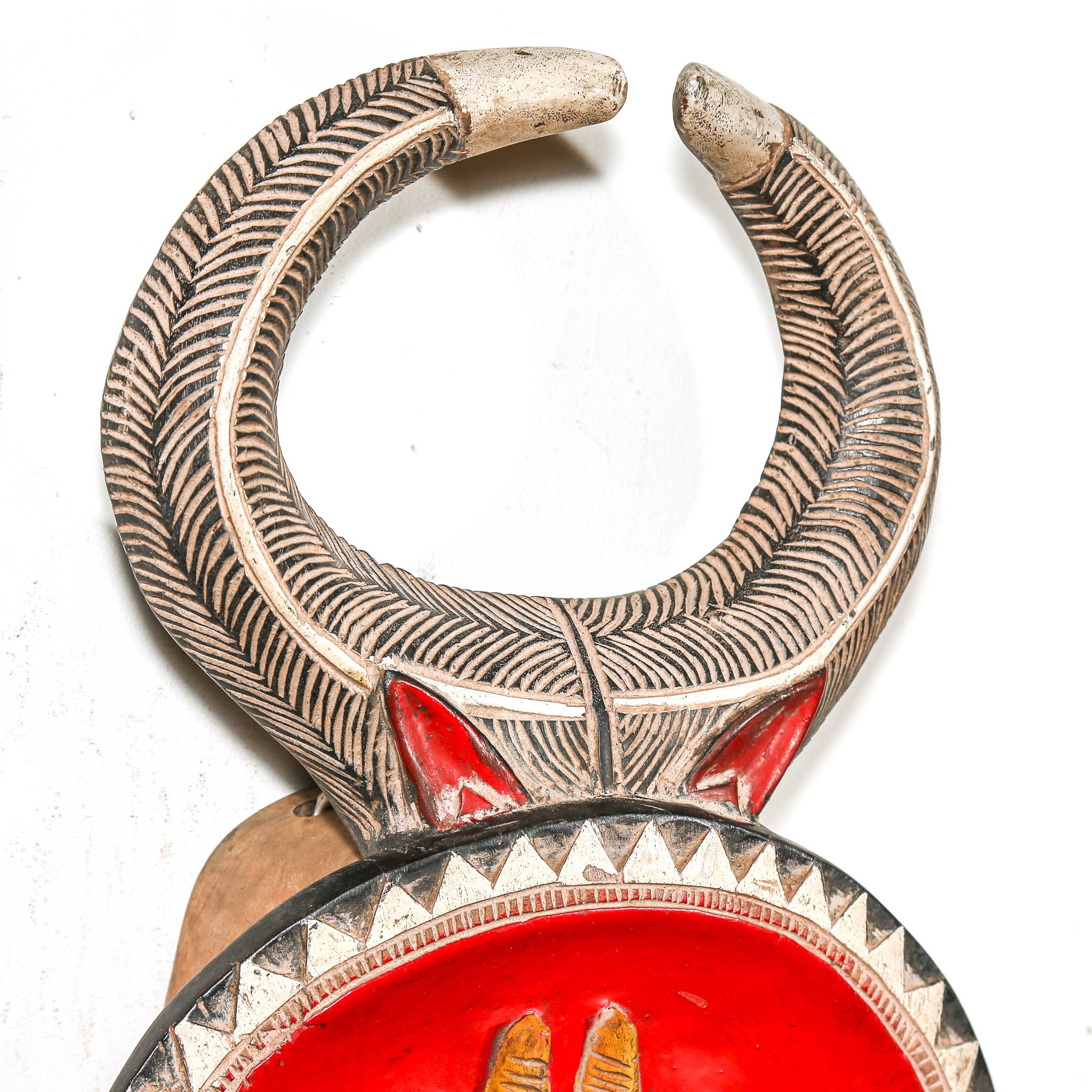 detail of the horns on a african bull mask to hang in living room