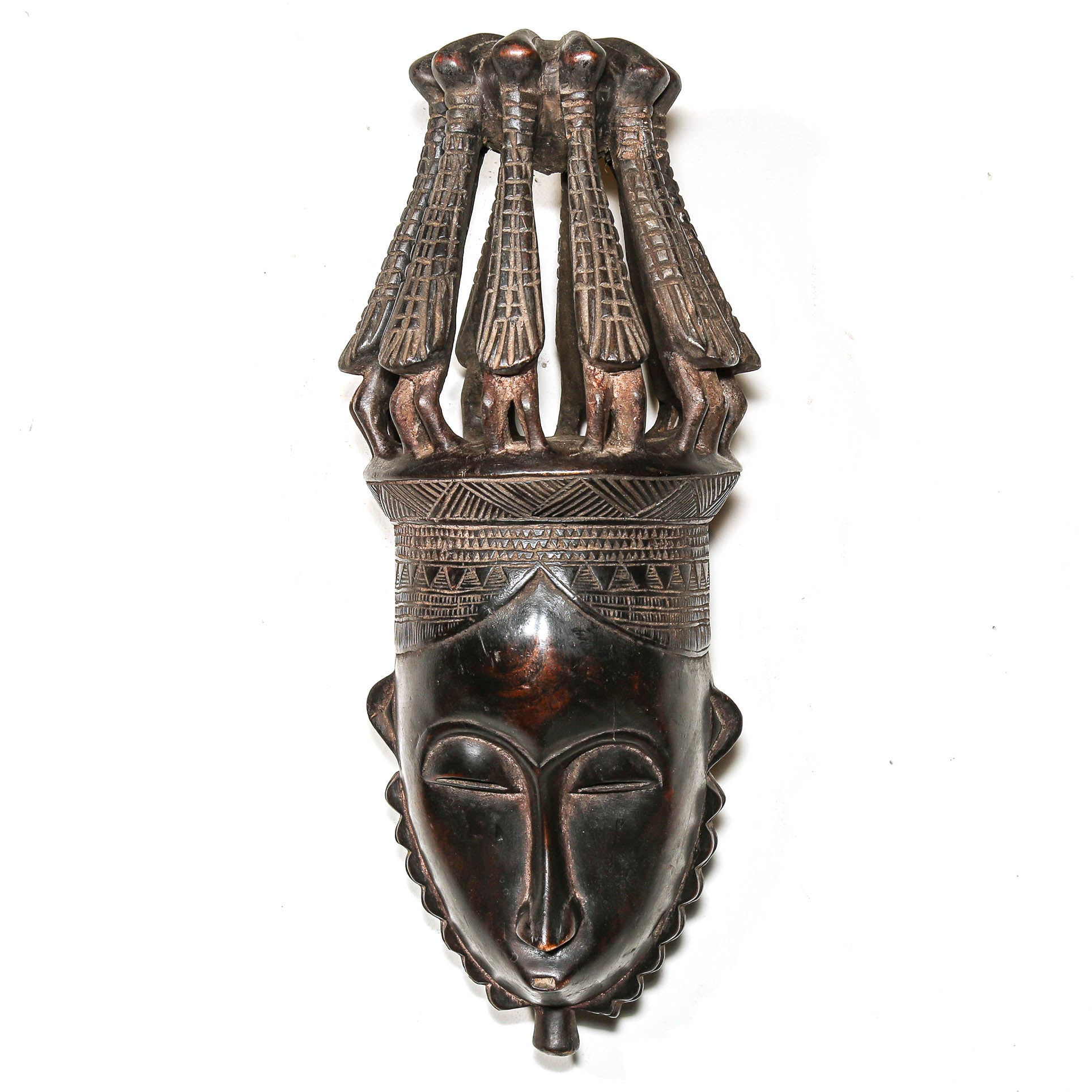 African mask with bird headdress on a white wall