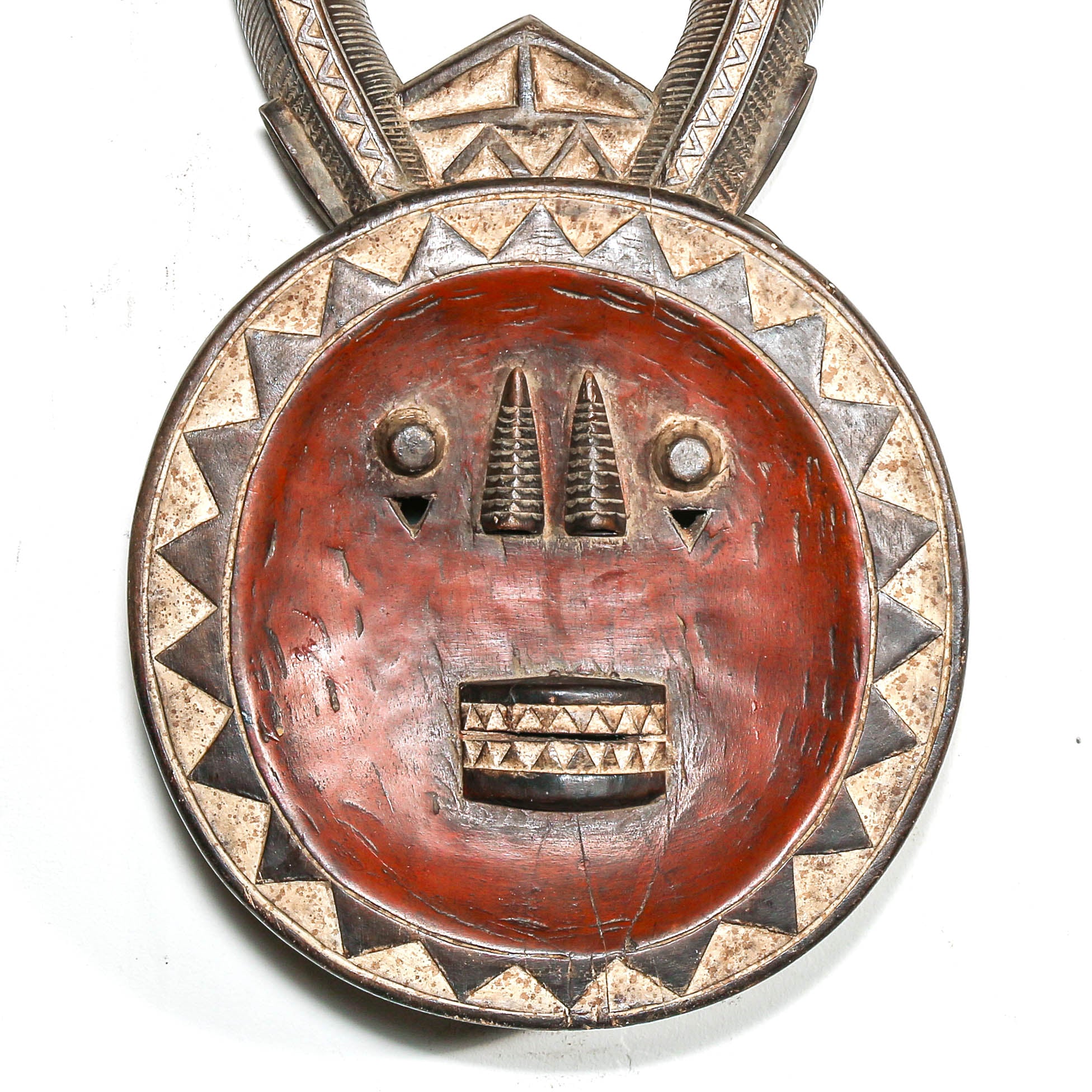 Decorative mask with red face and silver and gold accents on a white background