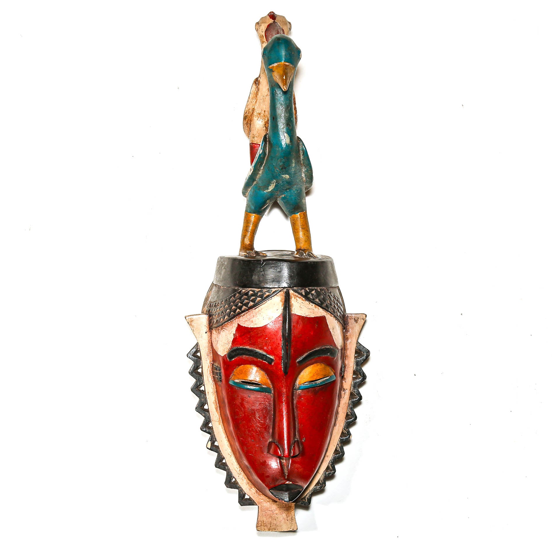 Decorative mask with a red face and colorful birds on a white living room wall