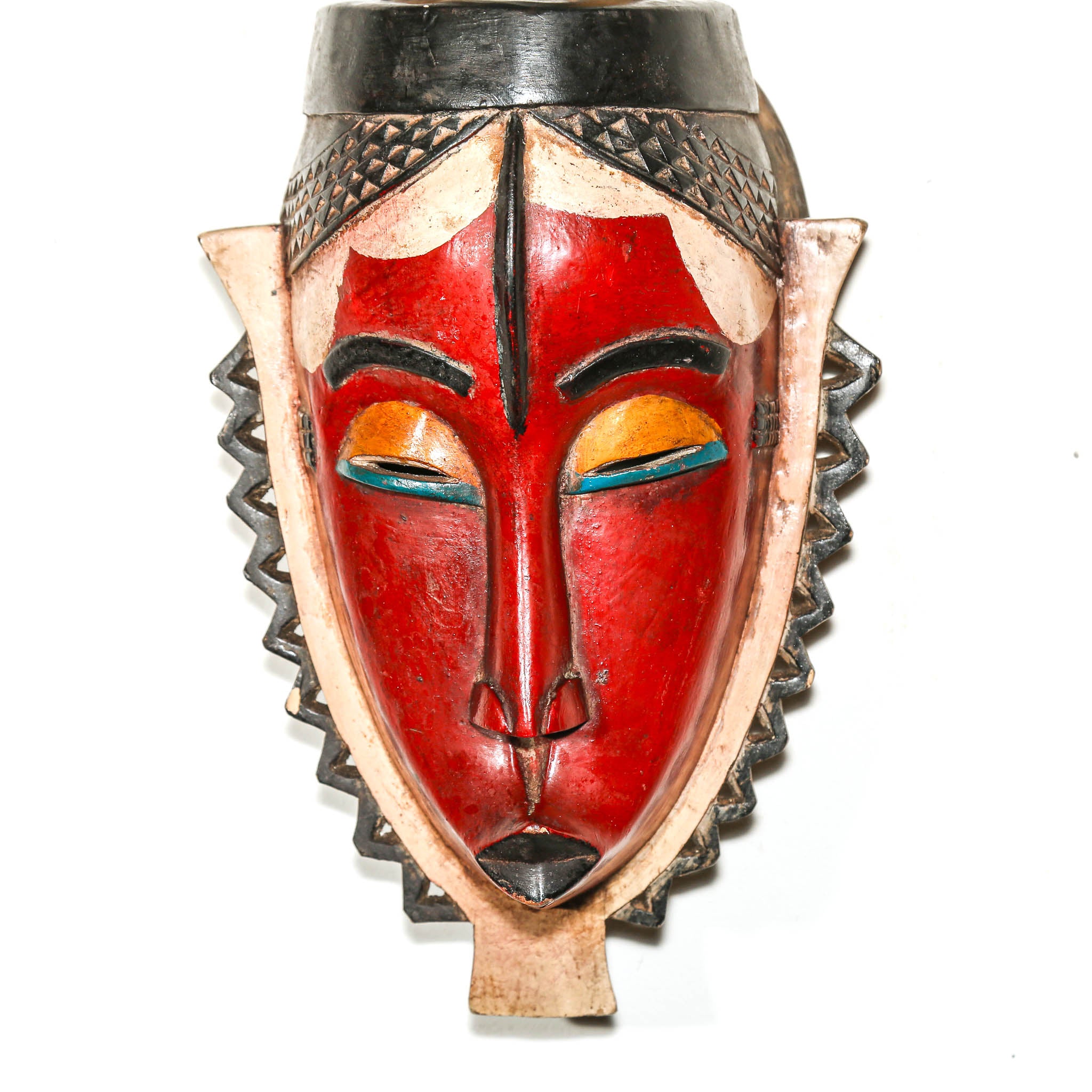 Decorative mask with red face, black and gold accents on a white background