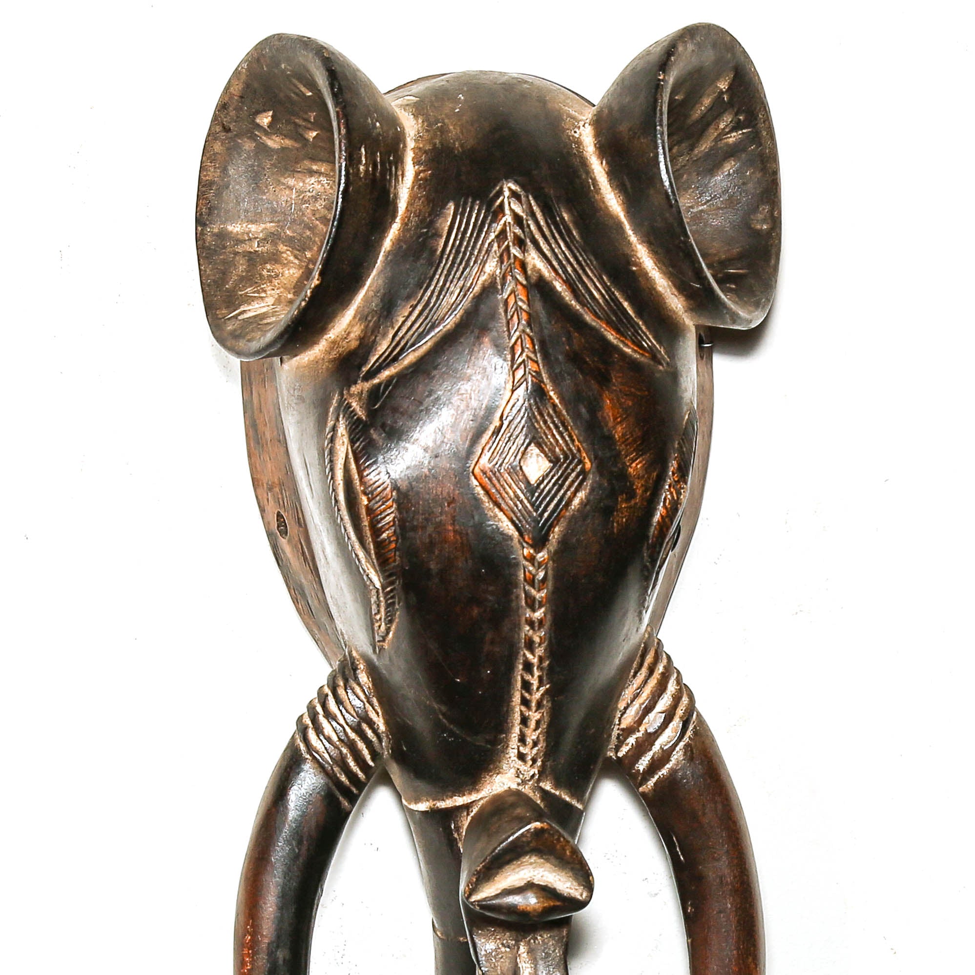 wooden elephant mask on a white wall