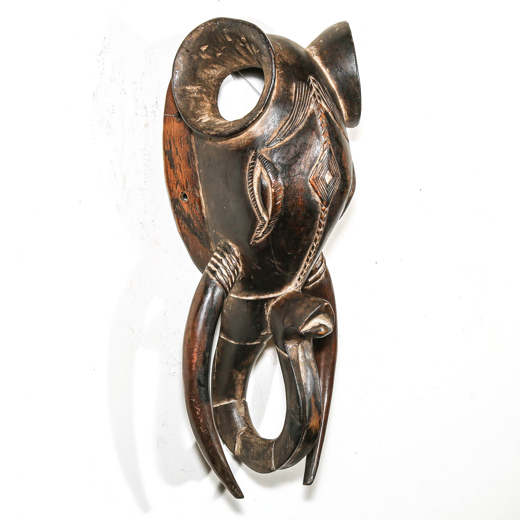 Decorative wooden wall hanging with intricate carvings on a white background