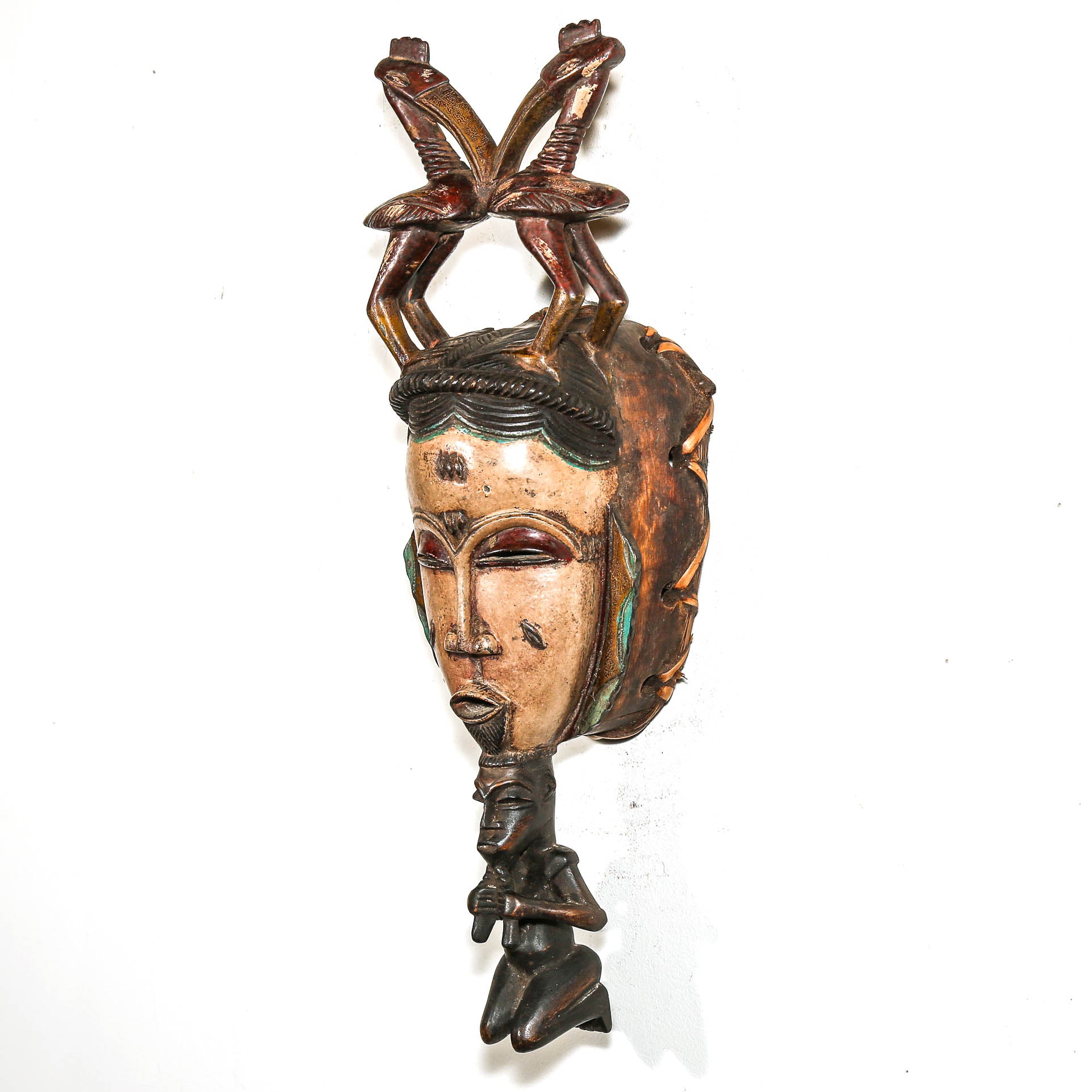 Decorative tribal black art mask with intricate designs on a white background