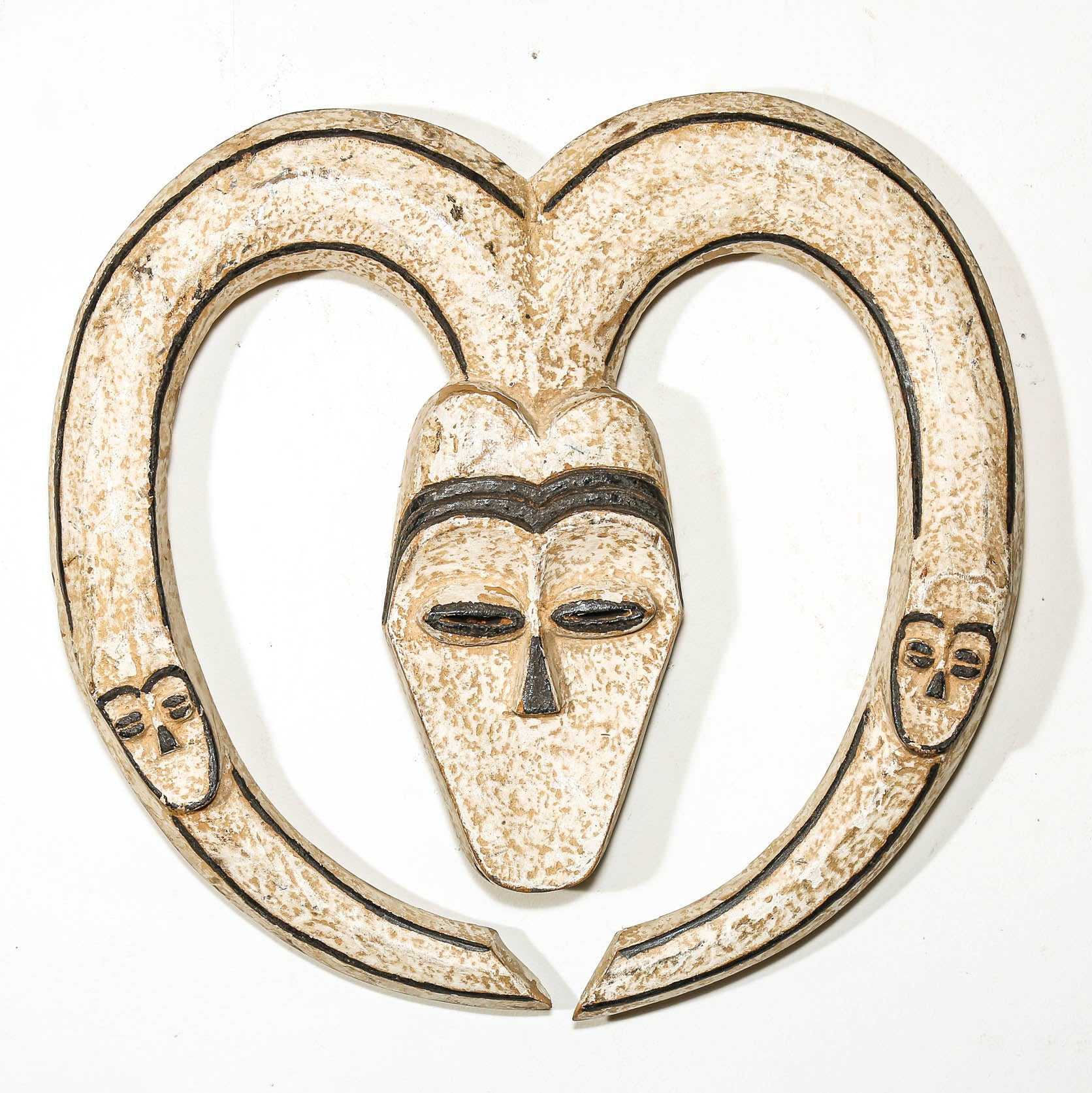 Decorative wall hanging African mask with a heart shape and black lines on a white background