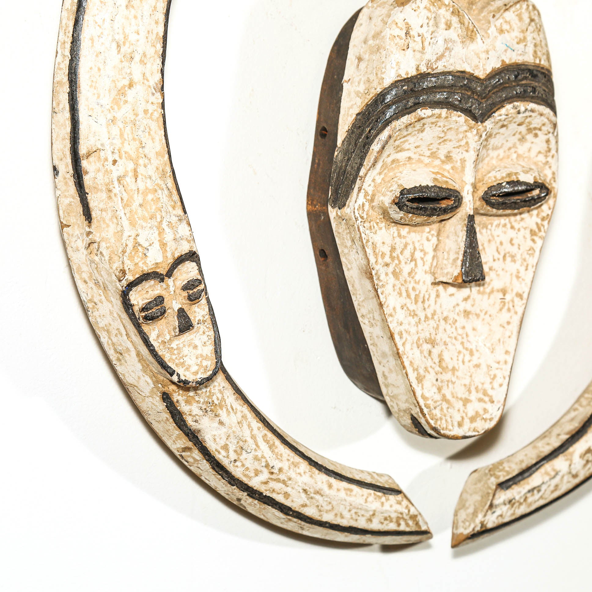 Decorative wall hanging African mask with a heart shape and black lines on a white background