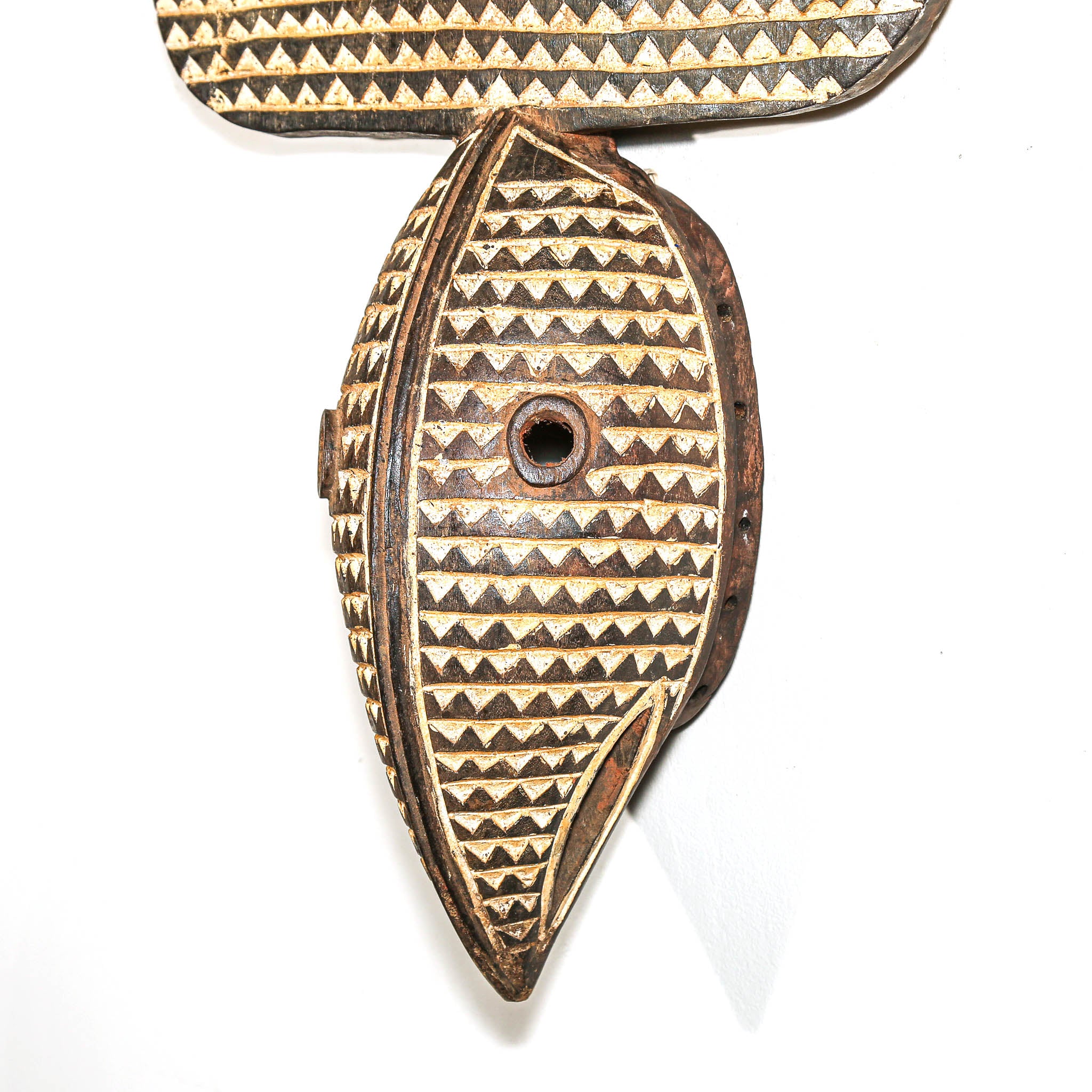 Black and white African Wooden mask with geometric patterns on a white background