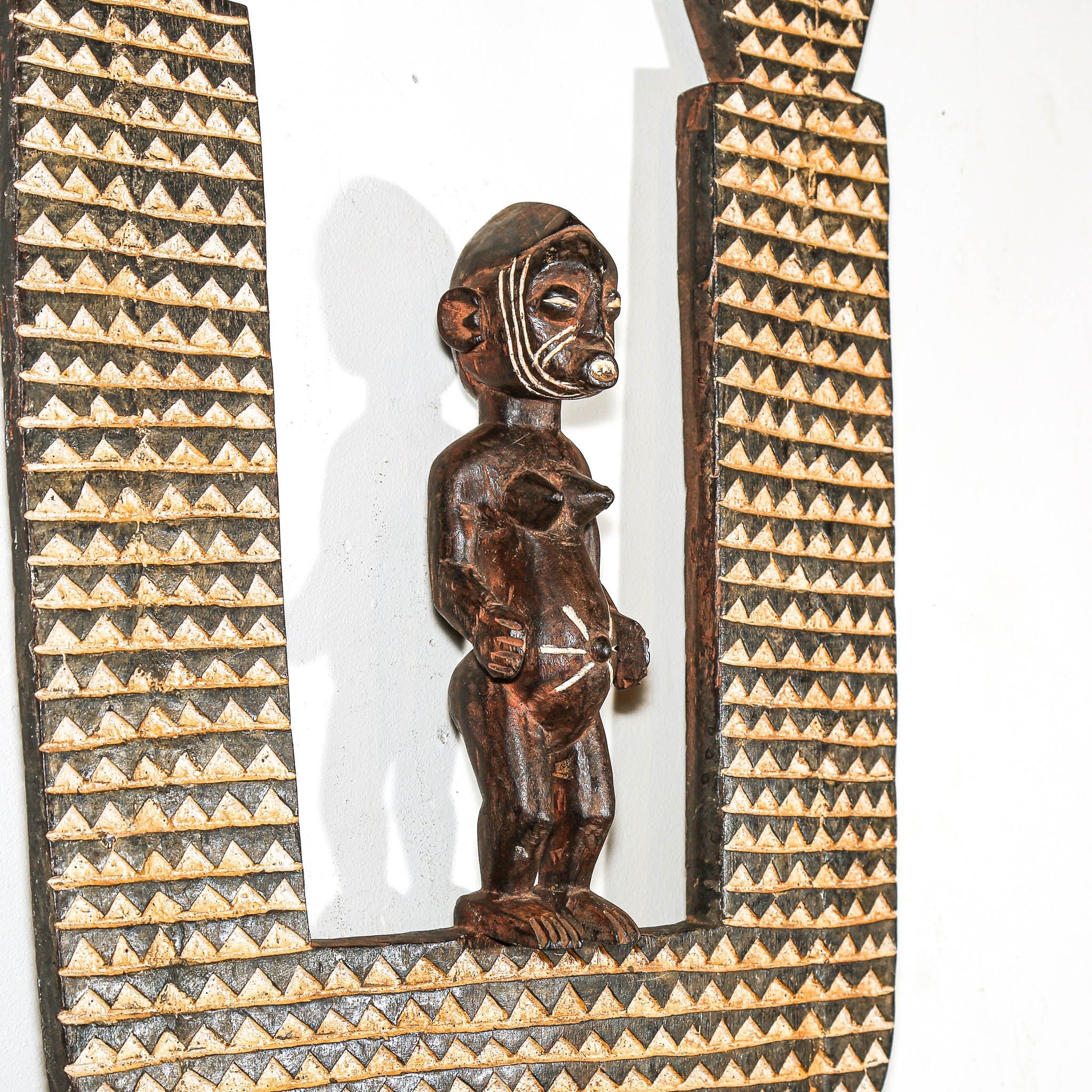 Wooden figure with geometric patterns on a white background