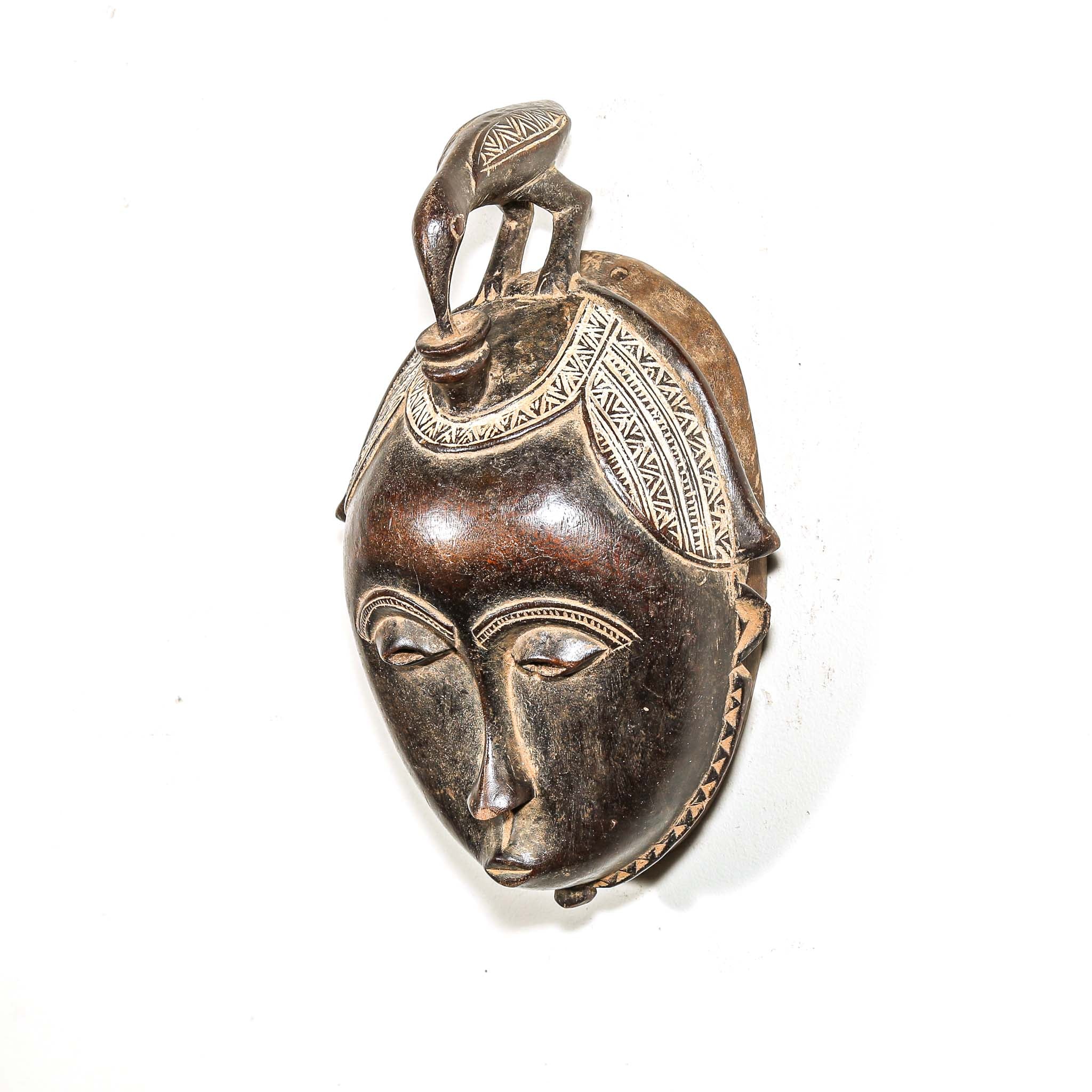Bronze mask pendant on a white background