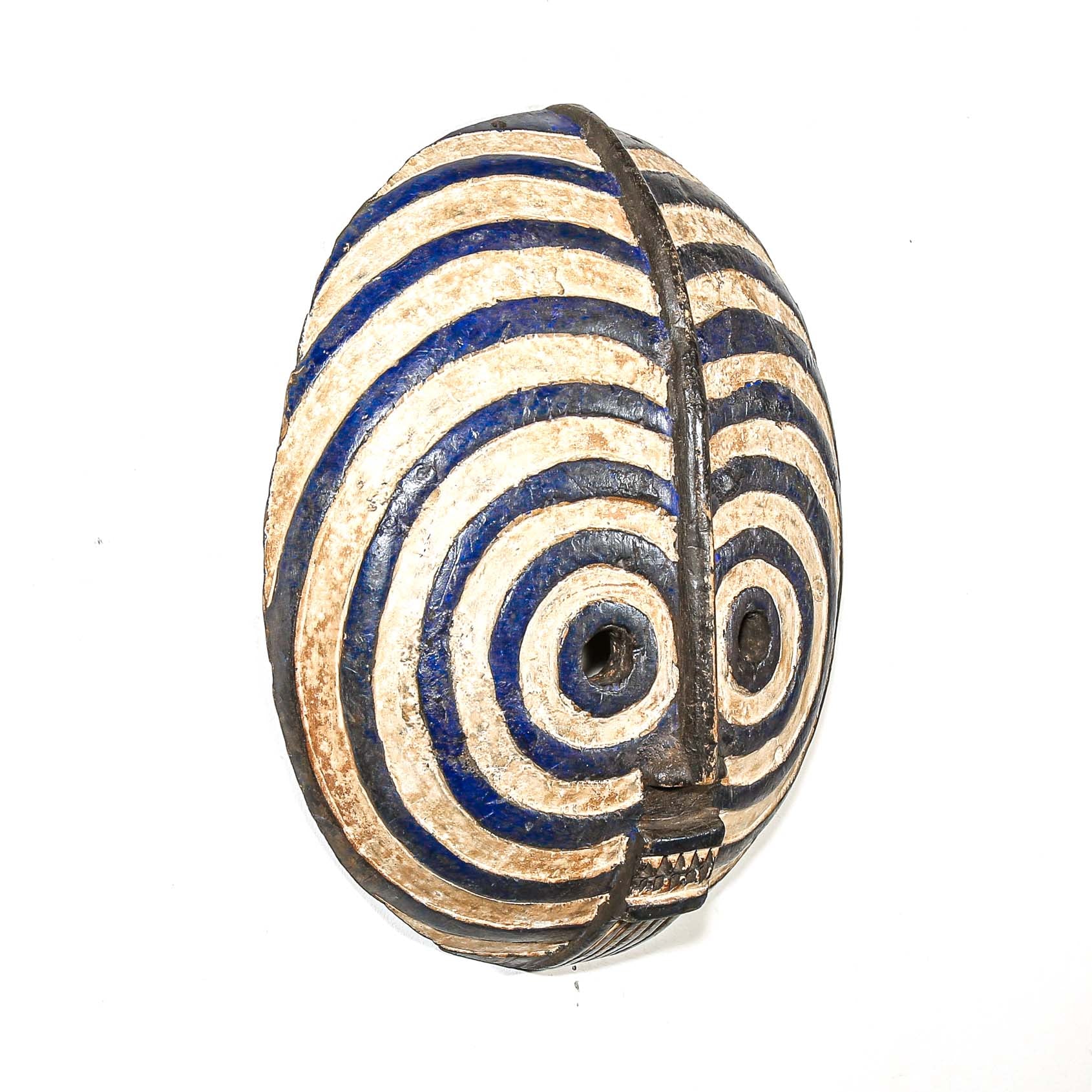 round Decorative African mask with blue and beige concentric circles on a white background