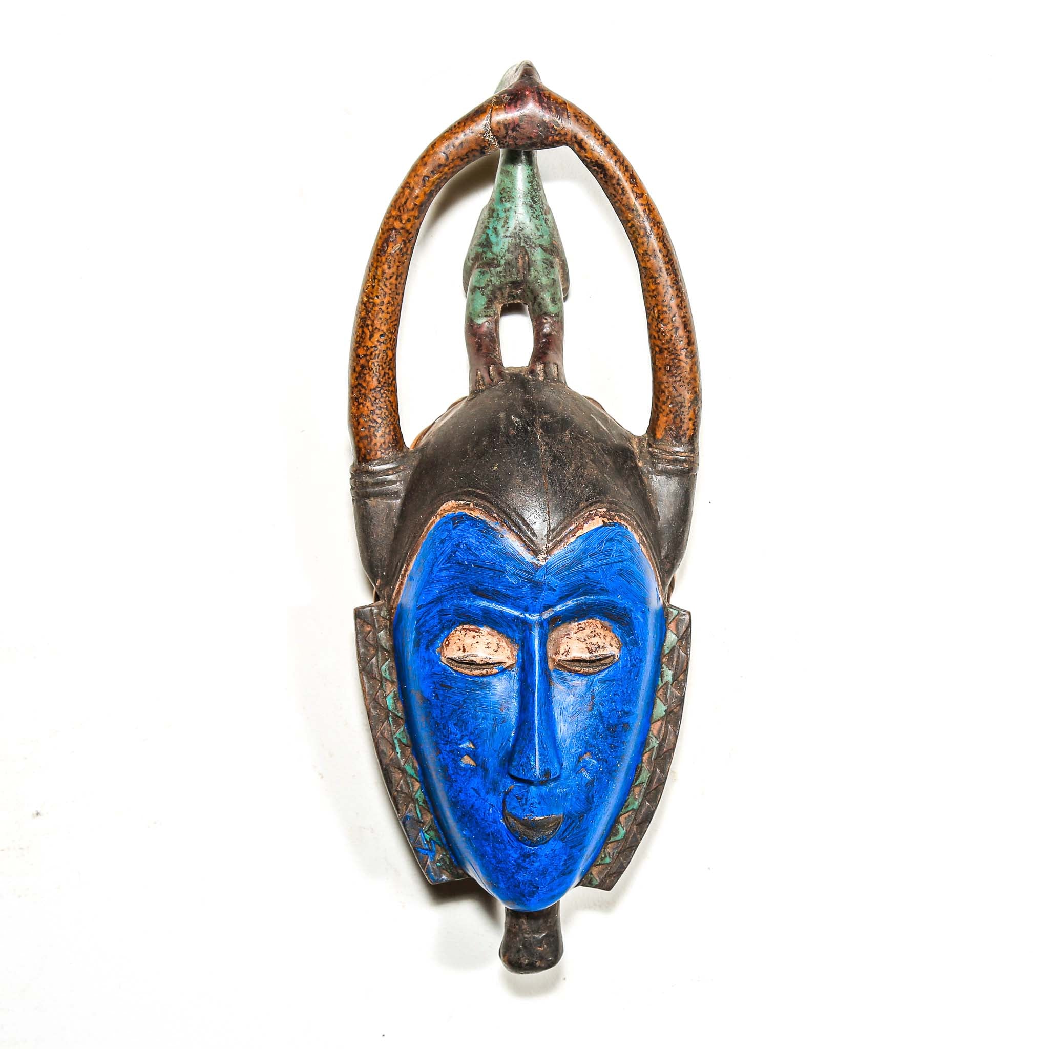 Decorative wooden African mask with blue face and brown arch on a white background authentic art and artist from Africa