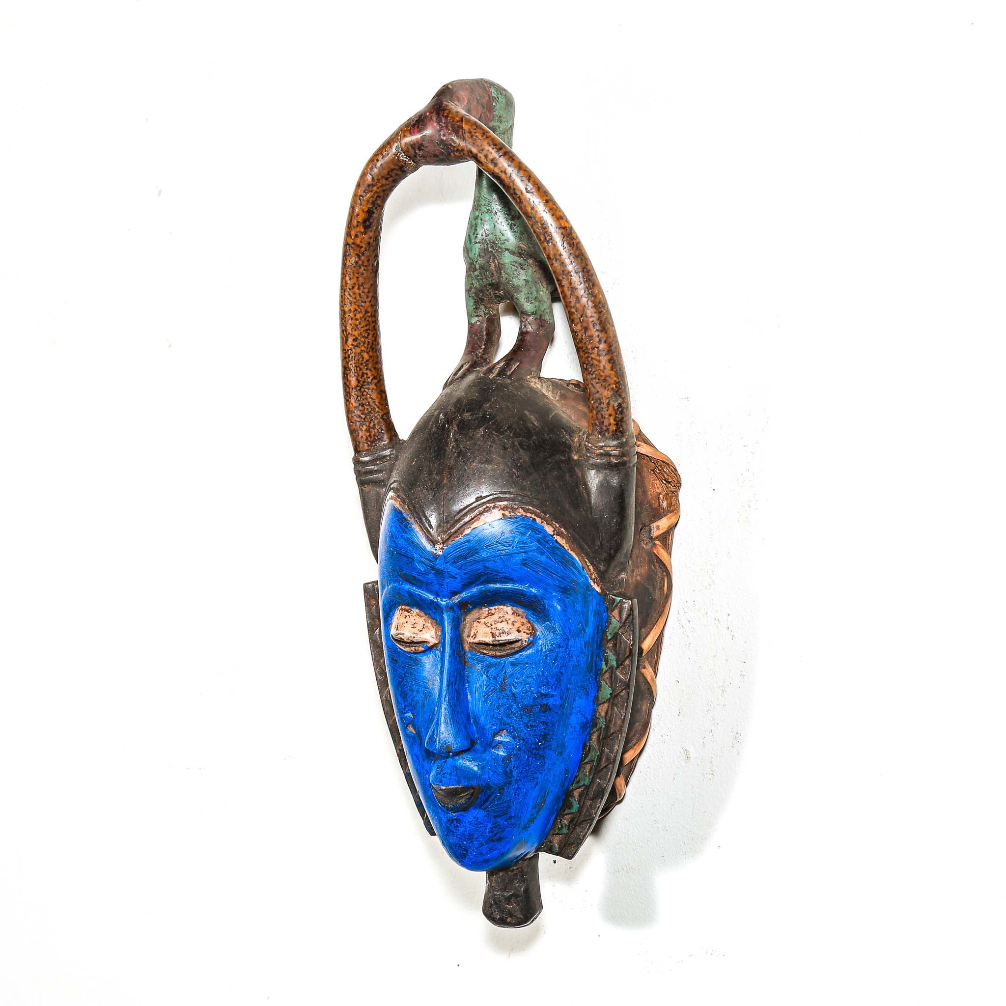 Decorative wooden African mask with blue face and brown arch on a white background authentic art and artist from Africa