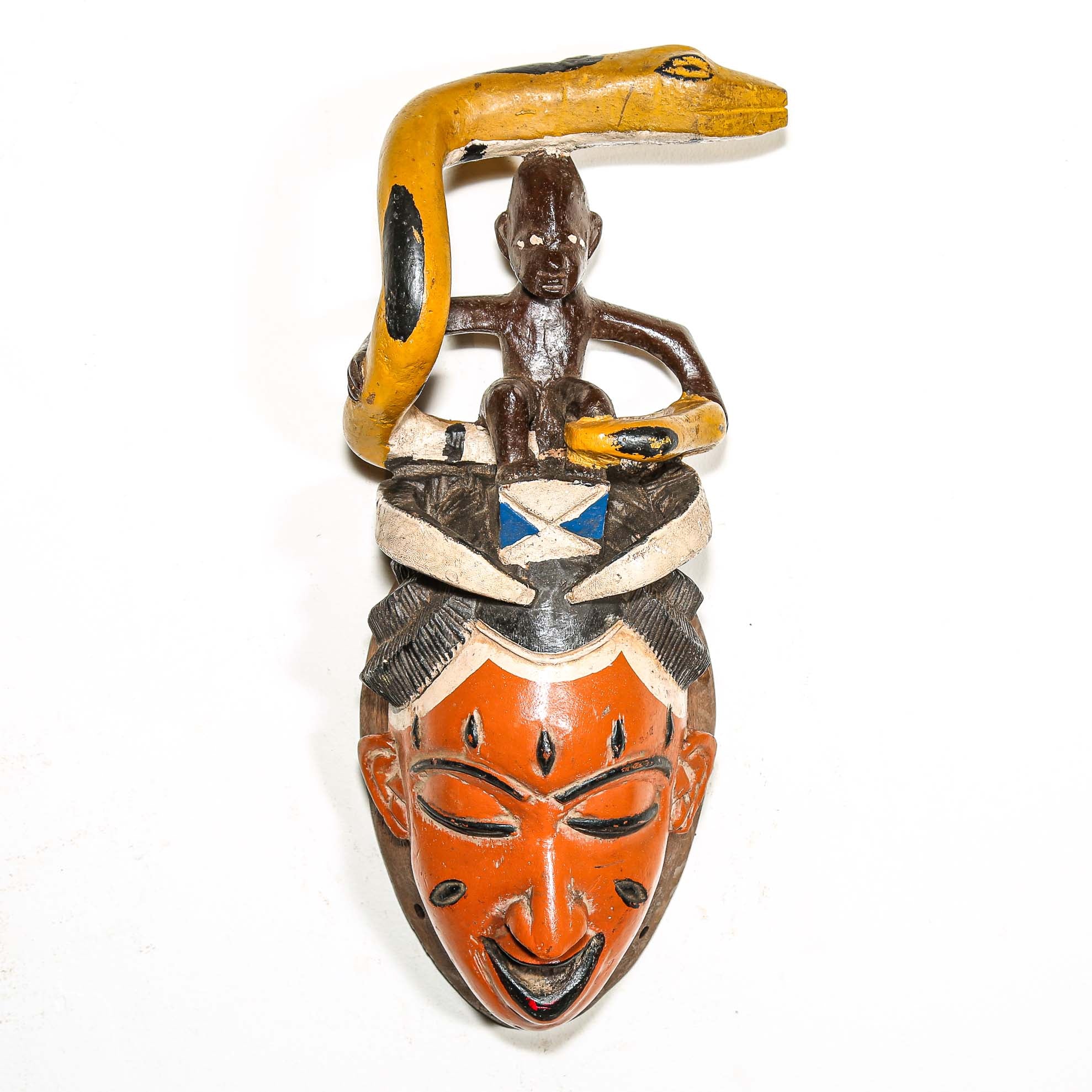 Decorative mask with a snake coiled around a figure from Africa on a white background