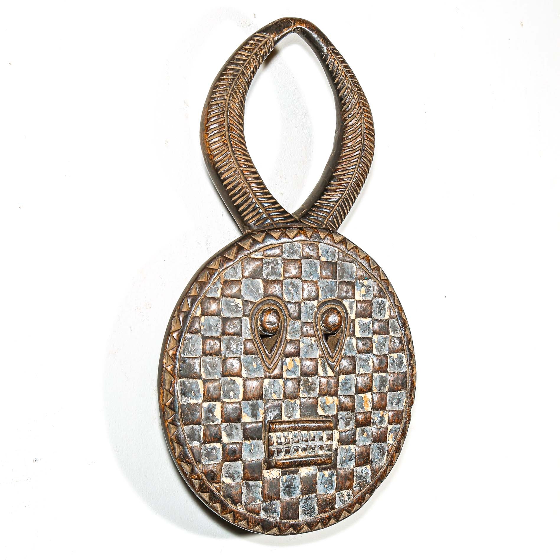 Decorative wooden traditional african mask with checkered pattern and eye design and horns on a white background