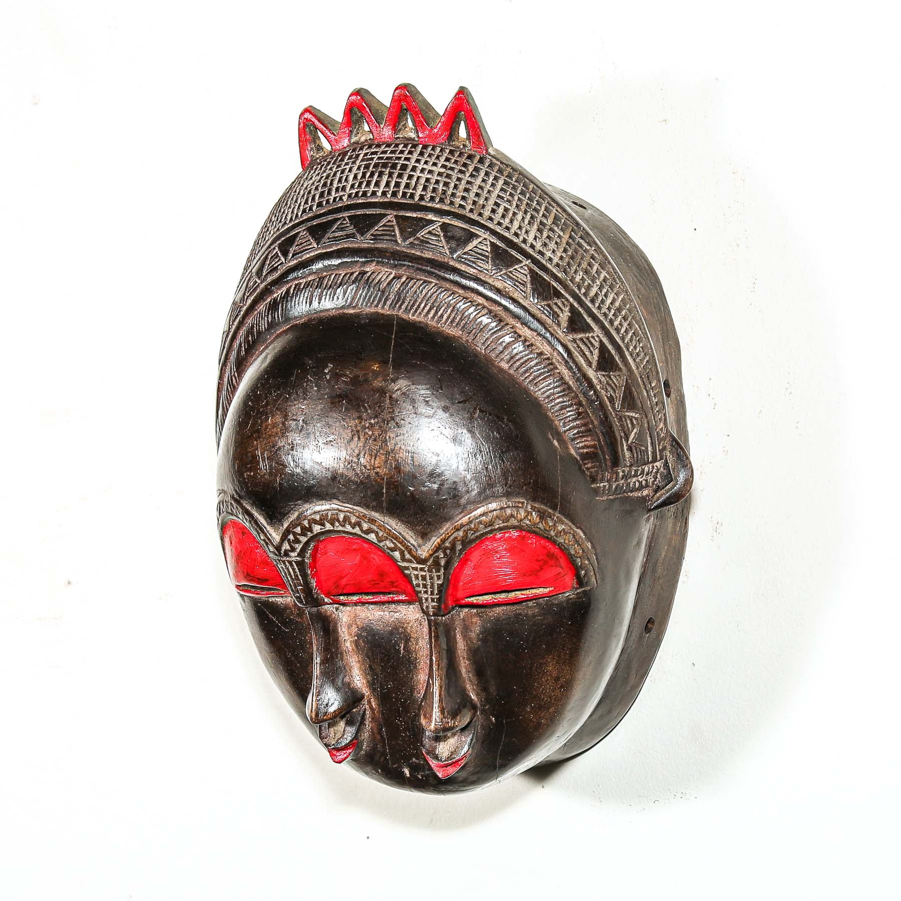 Decorative colorful african wooden mask with red accents on a white background