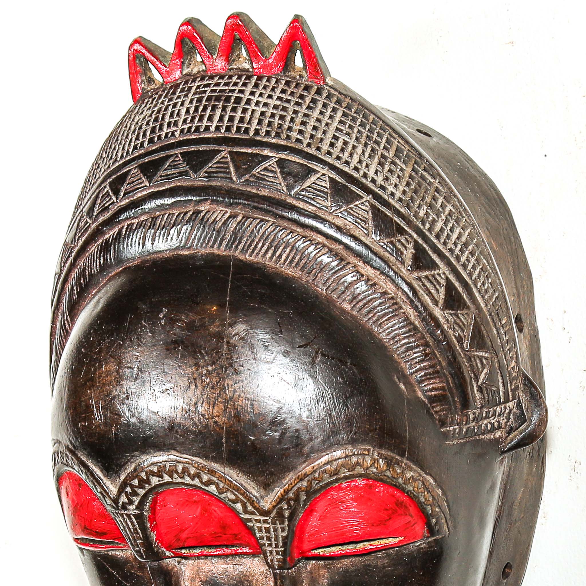 Decorative colorful african wooden mask with red accents on a white background