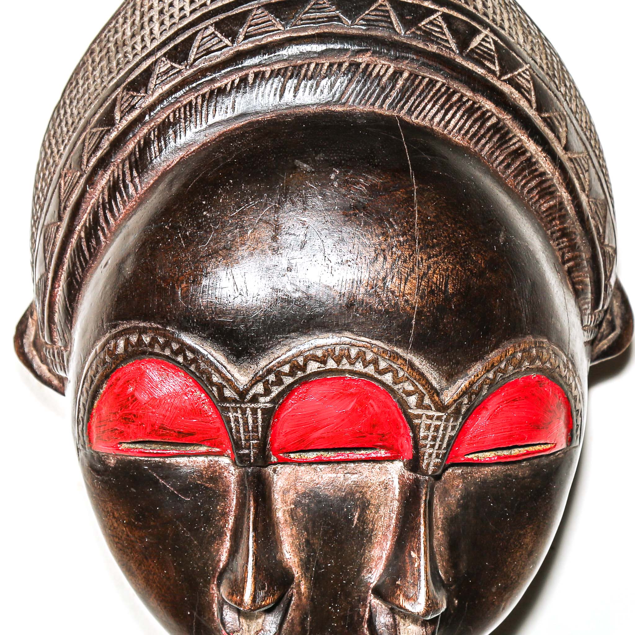 Decorative colorful african wooden mask with red accents on a white background