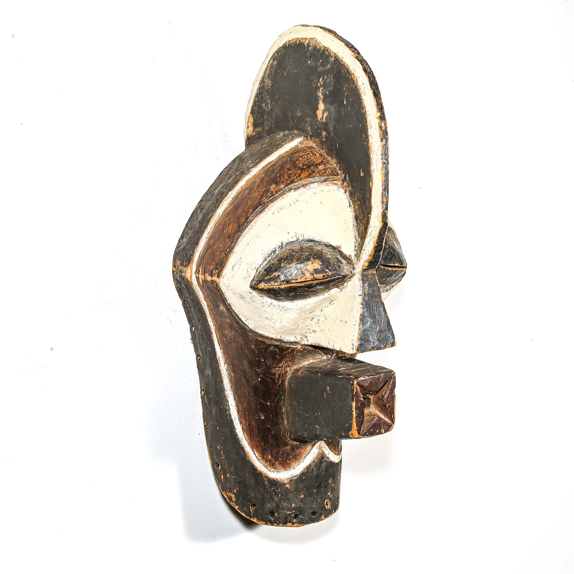 Wooden mask with black and white design on a white background