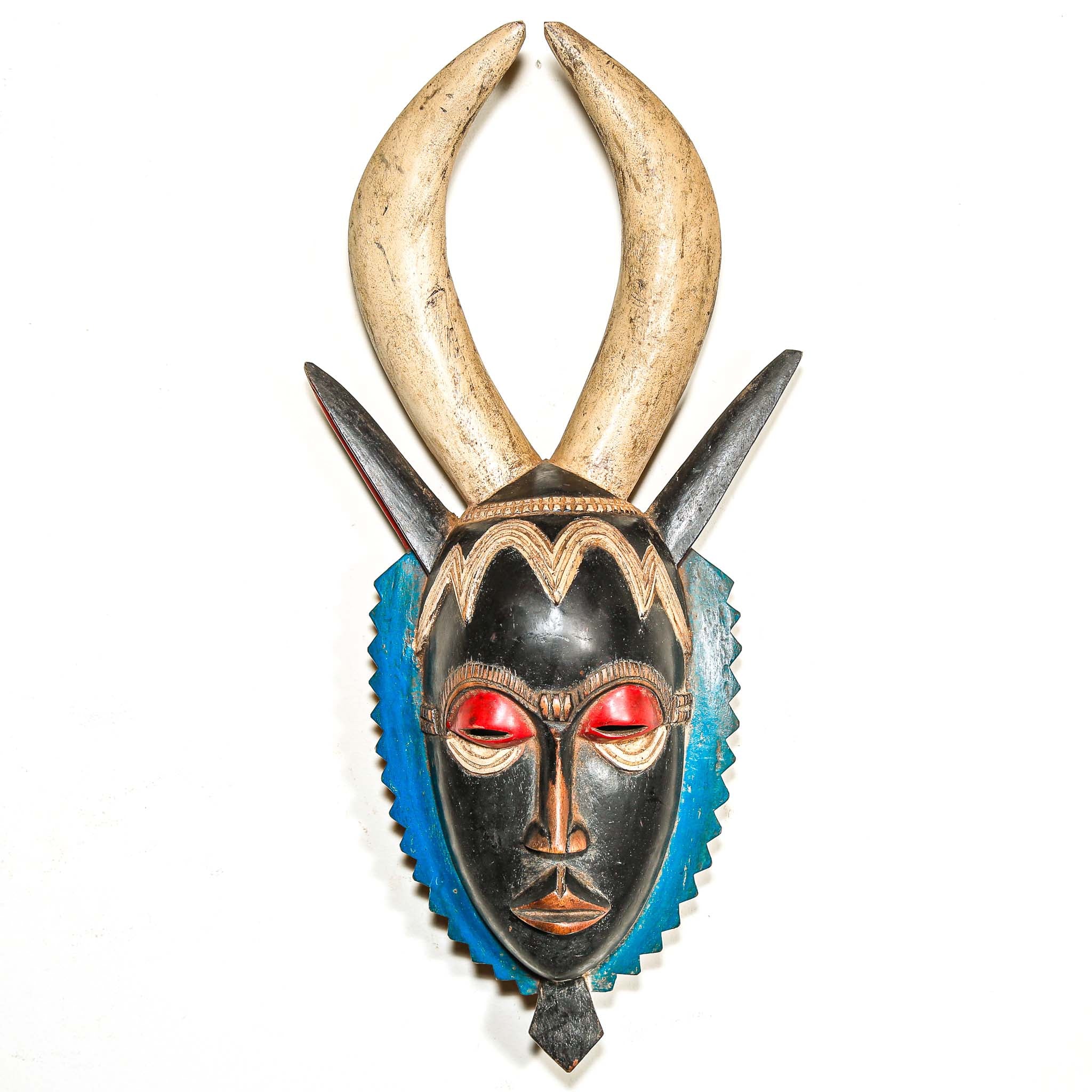 A vintage colorful African wood mask with large horns on a white background